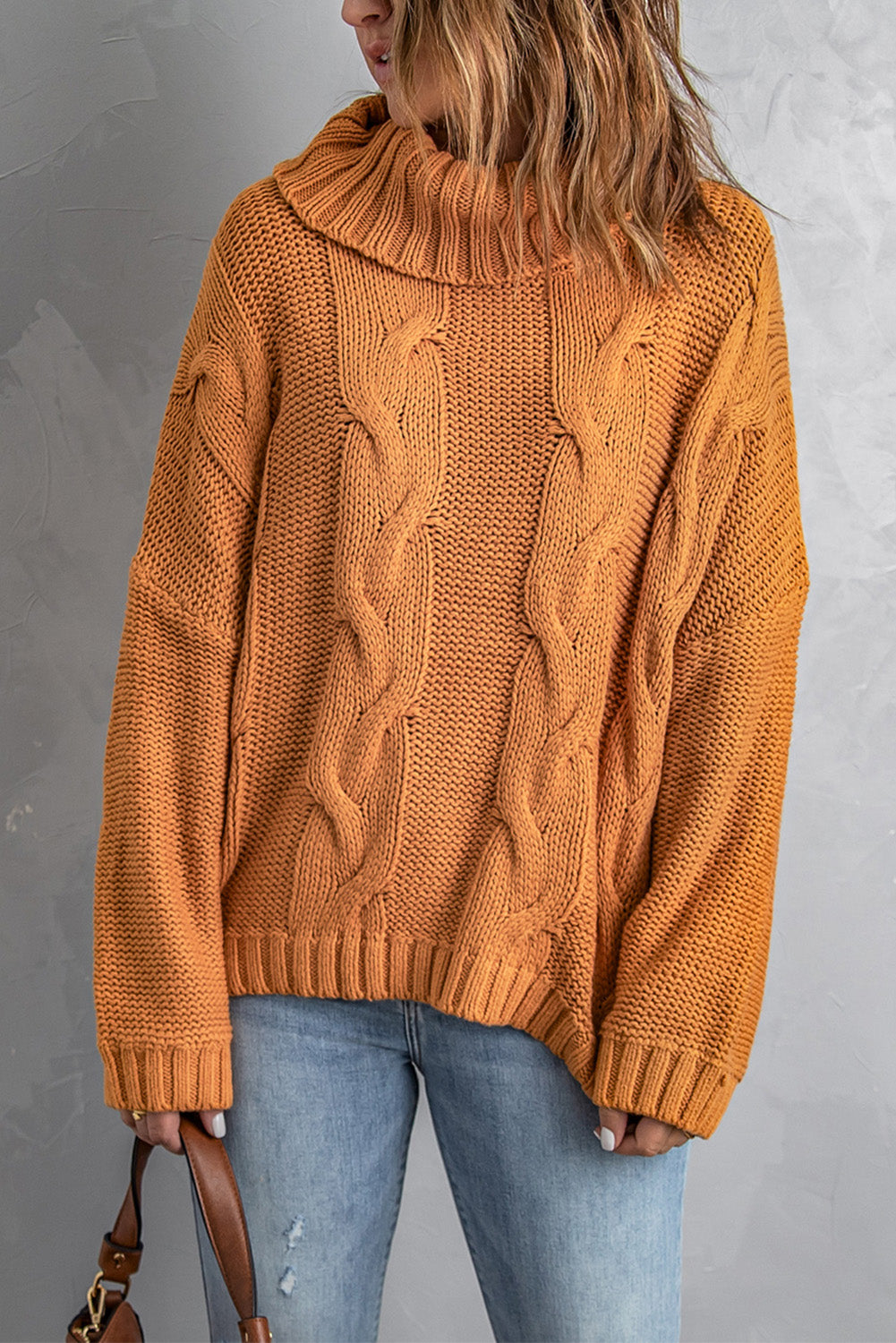 A vibrant yellow handmade cable knit turtleneck sweater displayed on a mannequin, showcasing its chunky texture and oversized fit.