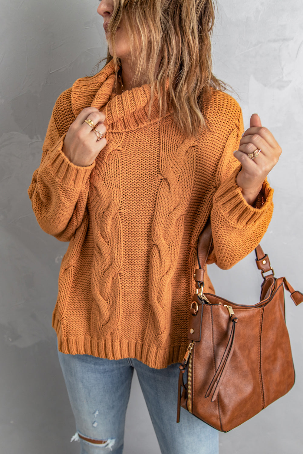 A vibrant yellow handmade cable knit turtleneck sweater displayed on a mannequin, showcasing its chunky texture and oversized fit.