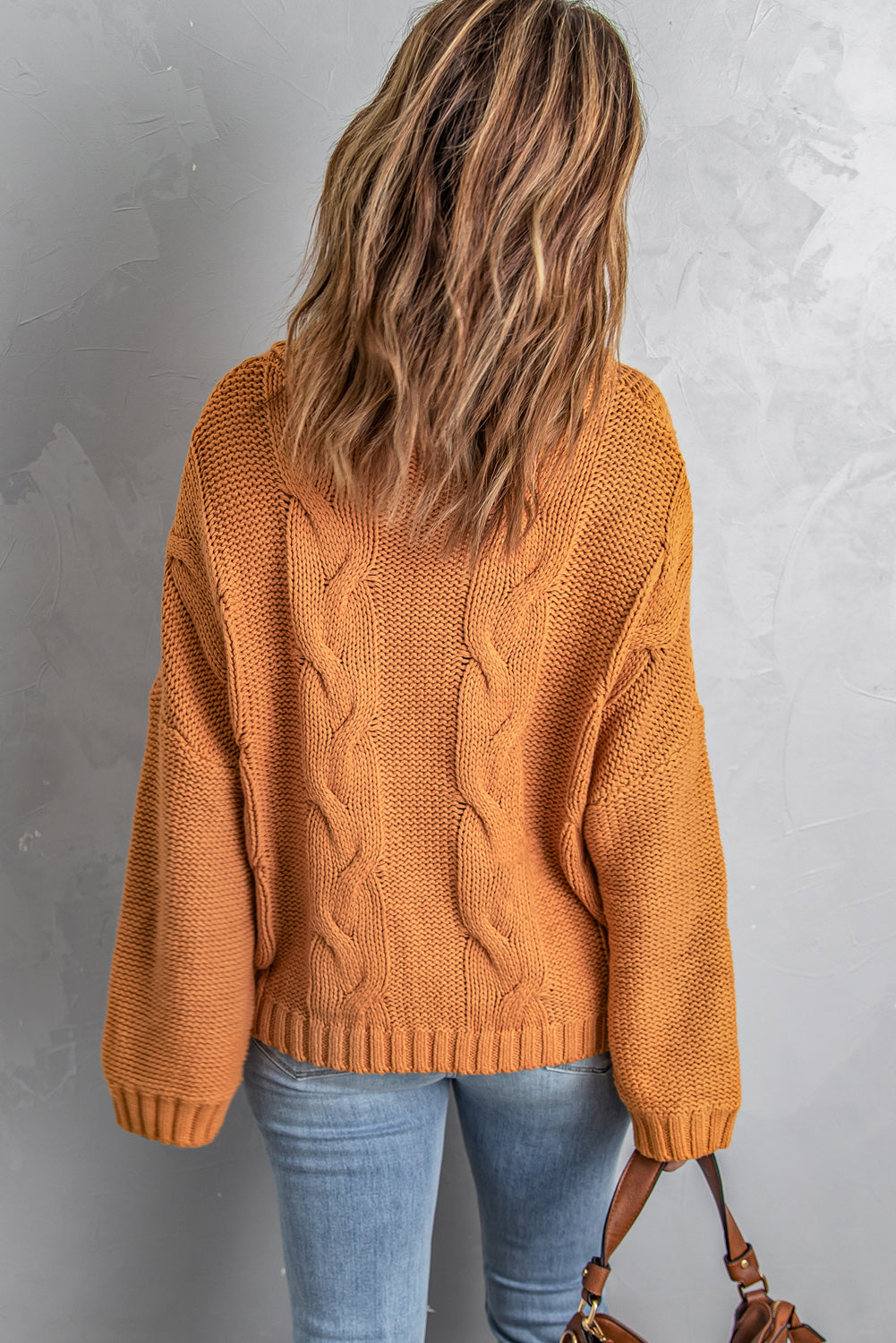 A vibrant yellow handmade cable knit turtleneck sweater displayed on a mannequin, showcasing its chunky texture and oversized fit.