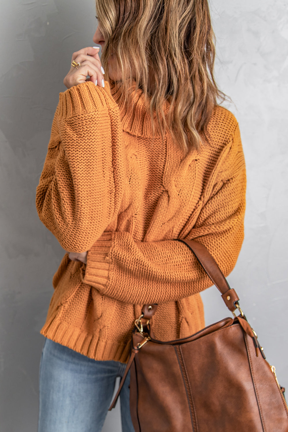 A vibrant yellow handmade cable knit turtleneck sweater displayed on a mannequin, showcasing its chunky texture and oversized fit.