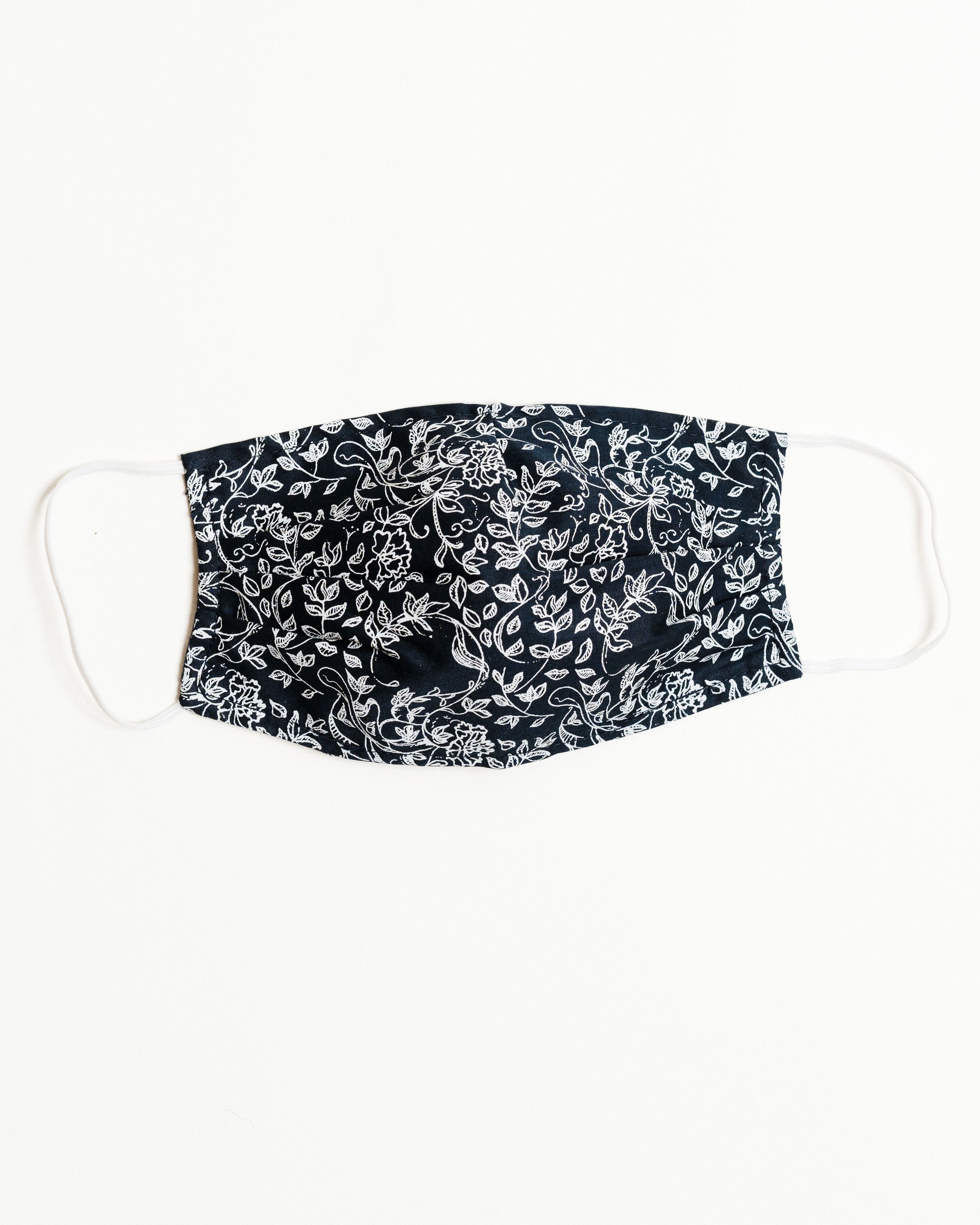 Normandy Floral Face Mask featuring a colorful floral pattern, made from 100% cotton with elastic ear straps and a pocket for filters.