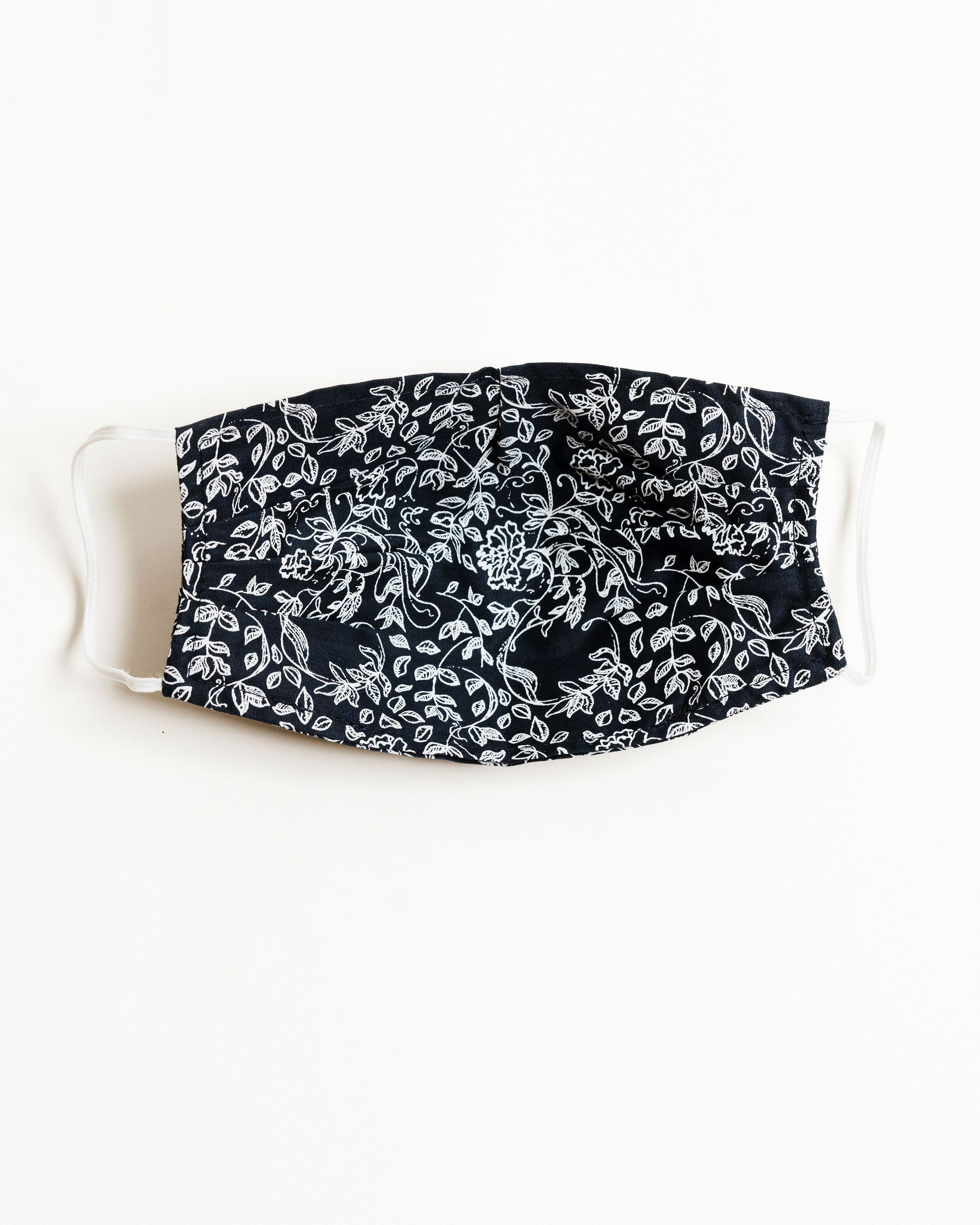 Normandy Floral Face Mask featuring a colorful floral pattern, made from 100% cotton with elastic ear straps and a pocket for filters.