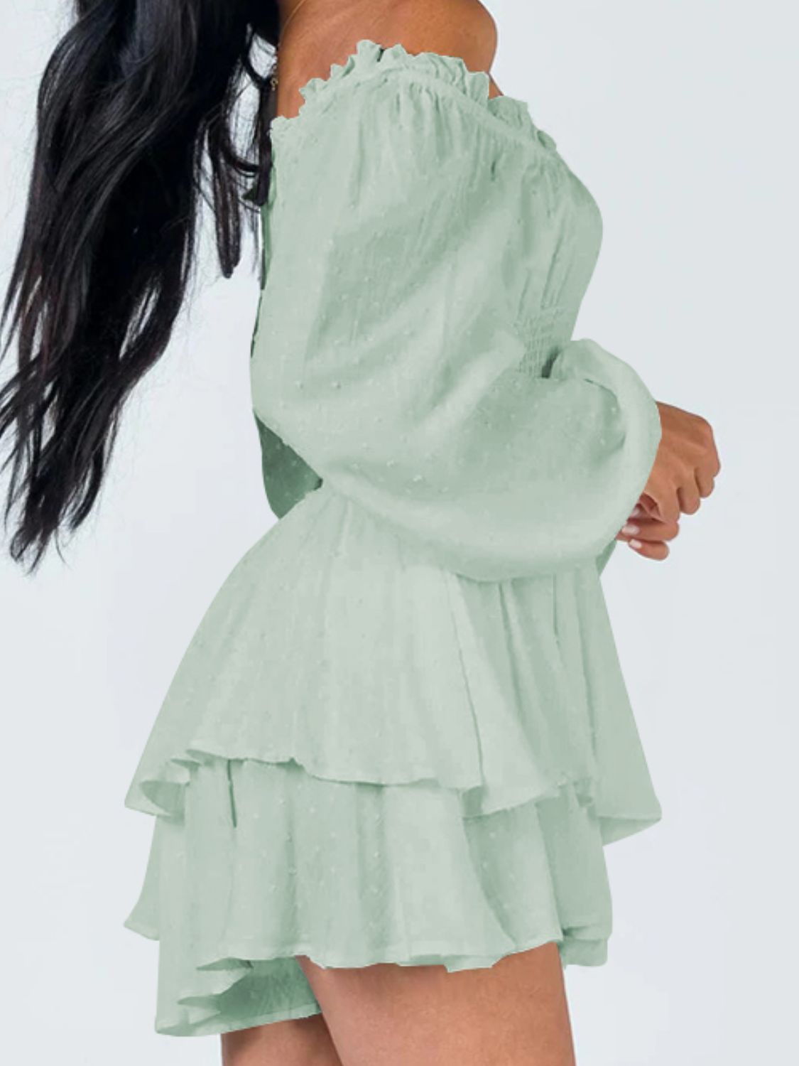 A stylish off-shoulder mini dress with a smocked waist and layered hem, featuring long sleeves and a solid pattern, perfect for casual outings.