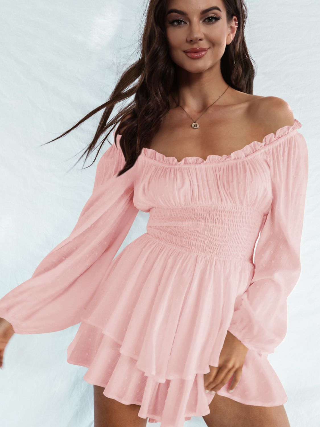 A stylish off-shoulder mini dress with a smocked waist and layered hem, featuring long sleeves and a solid pattern, perfect for casual outings.