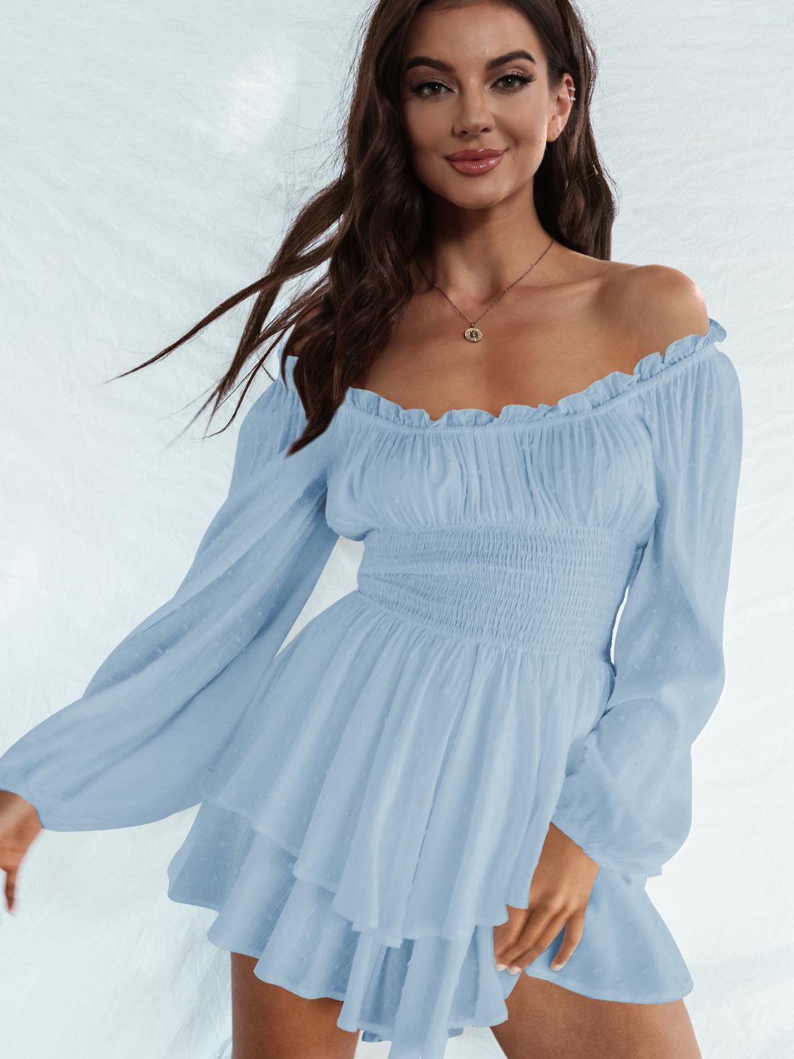 A stylish off-shoulder mini dress with a smocked waist and layered hem, featuring long sleeves and a solid pattern, perfect for casual outings.