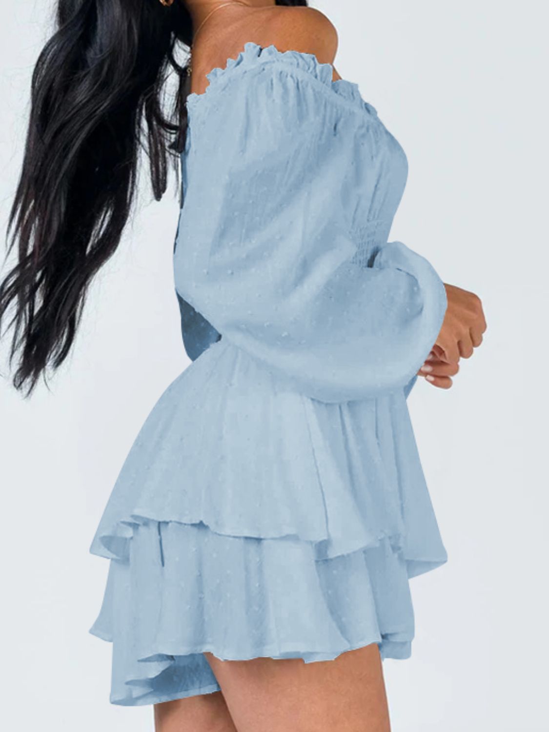 A stylish off-shoulder mini dress with a smocked waist and layered hem, featuring long sleeves and a solid pattern, perfect for casual outings.