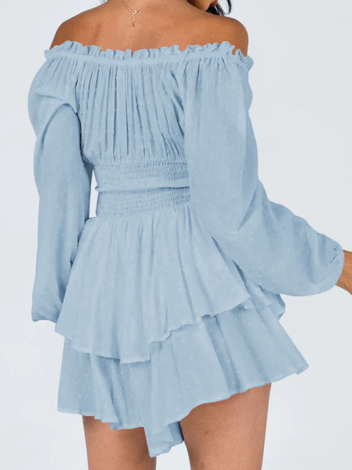 A stylish off-shoulder mini dress with a smocked waist and layered hem, featuring long sleeves and a solid pattern, perfect for casual outings.