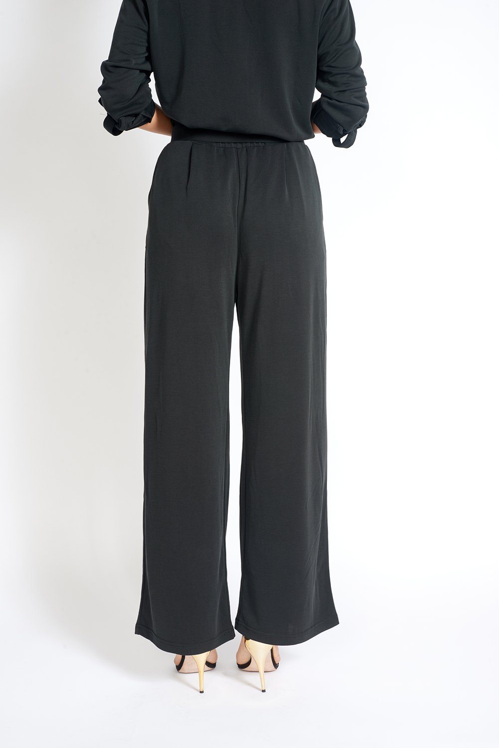 A pair of stylish black wide leg pants with an elasticized waist, showcasing a soft fabric and loose fit, ideal for office wear.