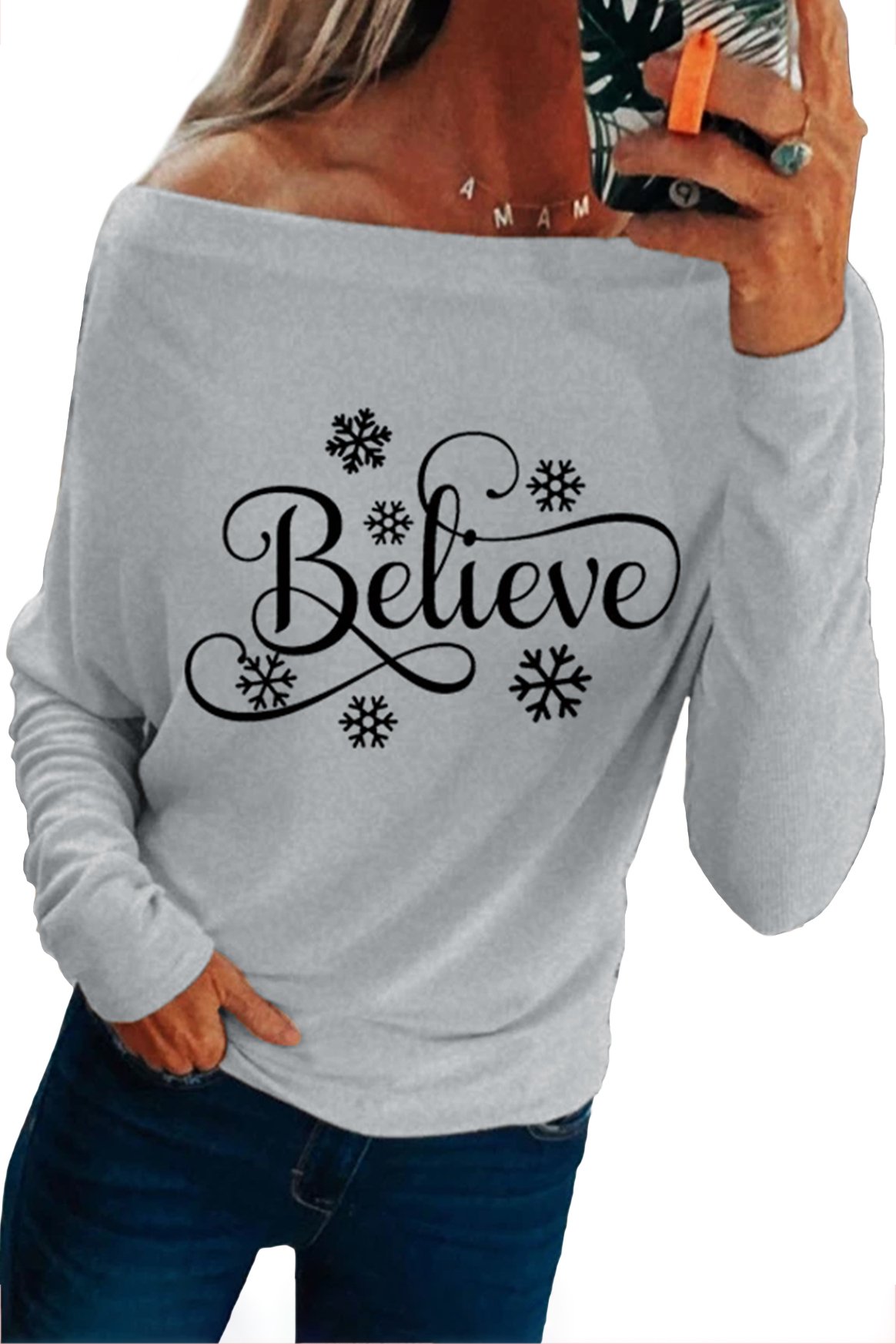 Off-the-shoulder long sleeve top featuring a snowflake pattern and 'Believe' print, perfect for holiday wear.