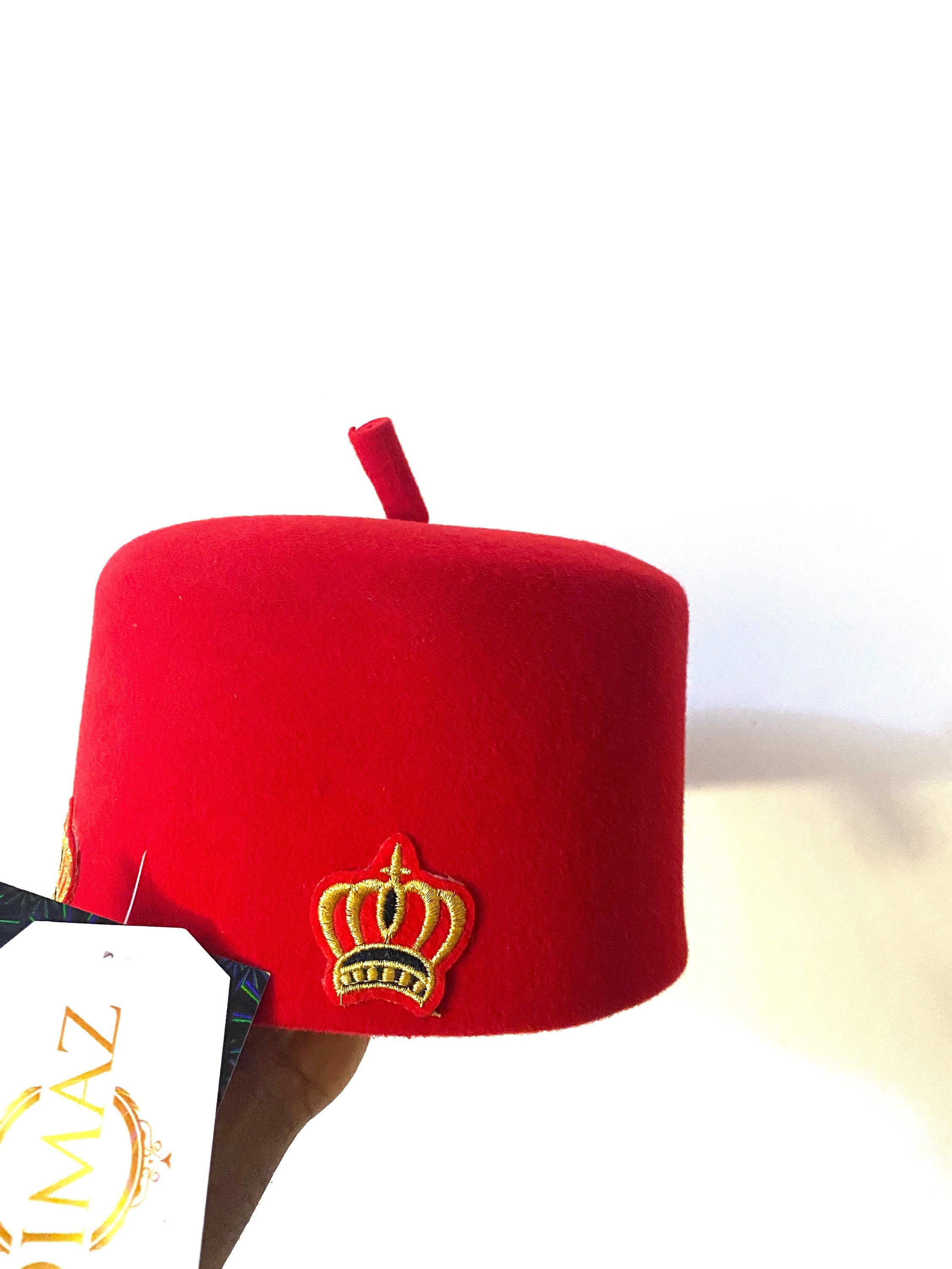 Ome Ego red cap with crown stamps, symbolizing Igbo authority and tradition, crafted from Czech wool.