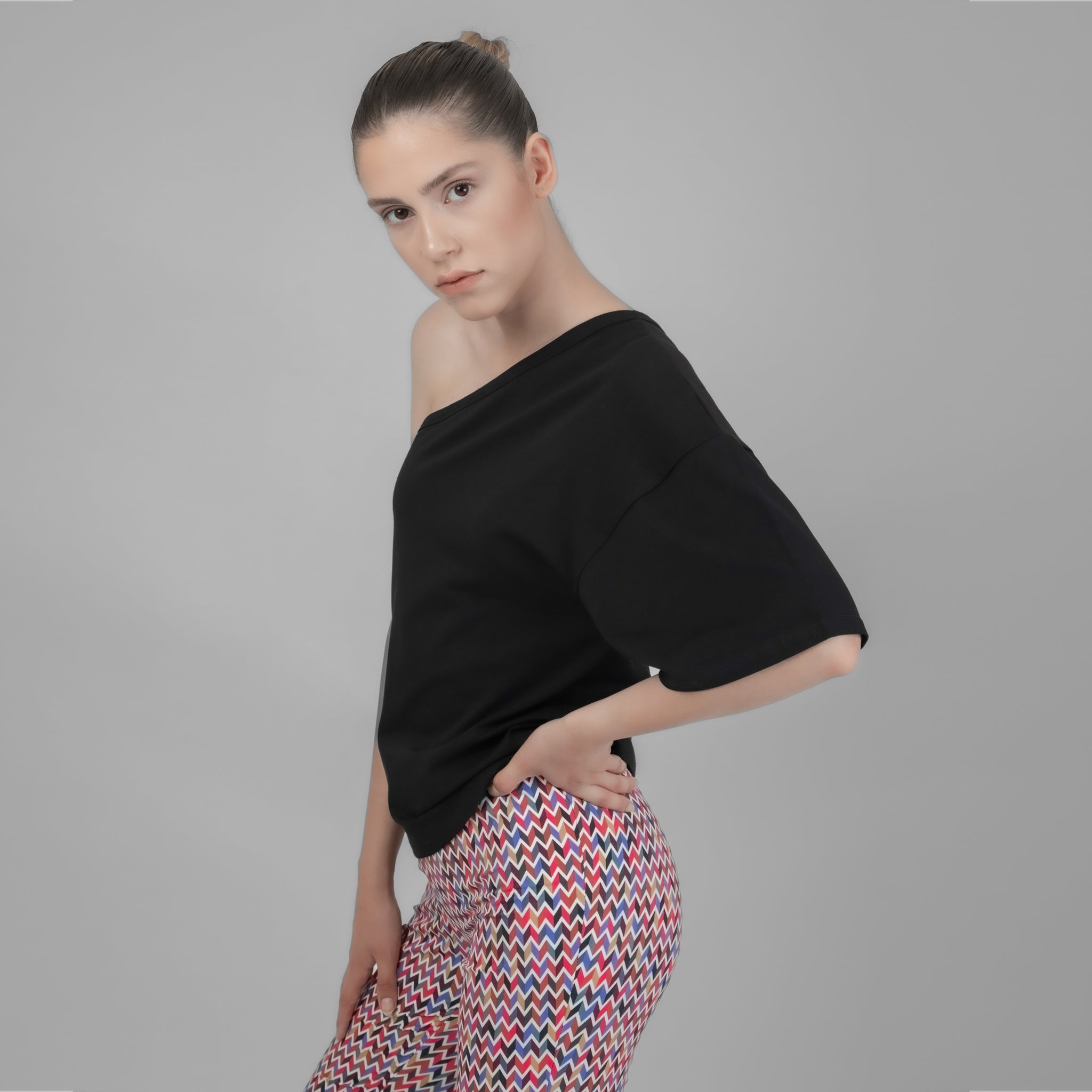 A stylish one shoulder black top made from cotton and elastane, showcasing a trendy asymmetrical design suitable for various occasions.