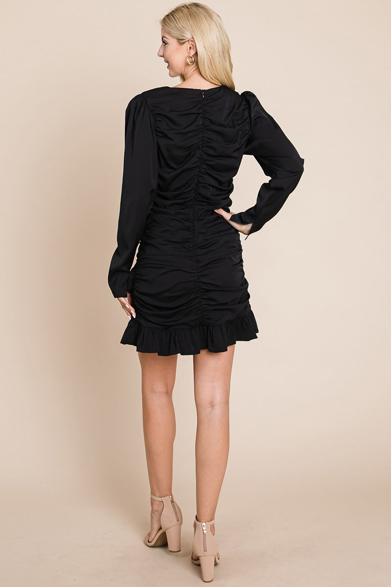 A stylish long sleeve mini dress featuring ruched sides, a boat neck, and a frill hem, perfect for various occasions.