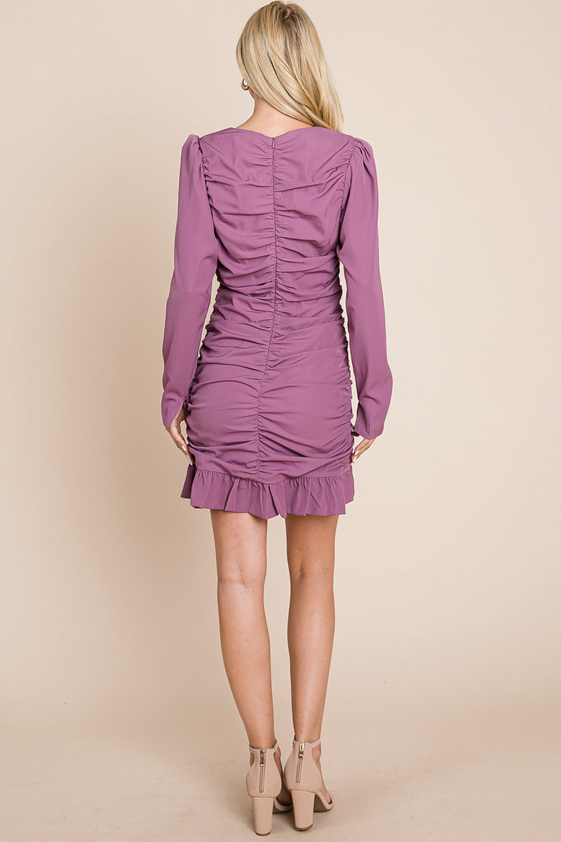 A stylish long sleeve mini dress featuring ruched sides, a boat neck, and a frill hem, perfect for various occasions.