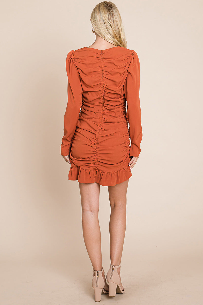 A stylish long sleeve mini dress featuring ruched sides, a boat neck, and a frill hem, perfect for various occasions.