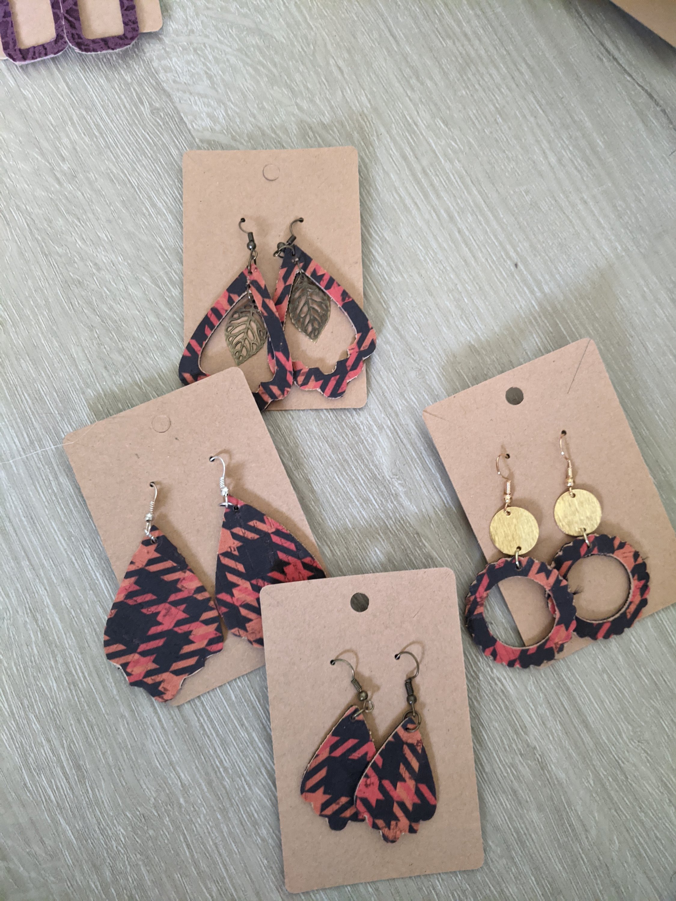 Handmade orange and black houndstooth earrings made from lightweight cork, featuring a trendy reversible design.