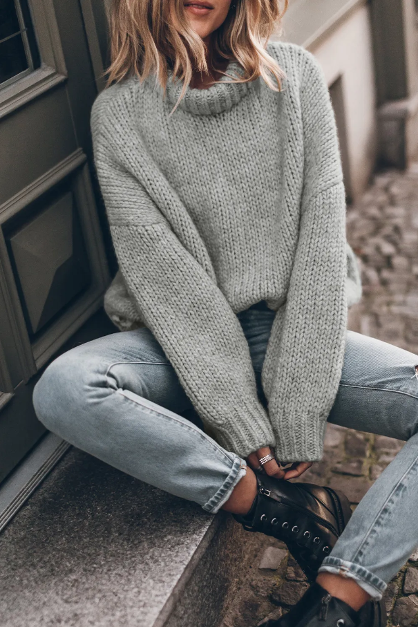 Light gray oversize turtleneck sweater with long sleeves, made from soft knitted fabric, perfect for stylish layering.