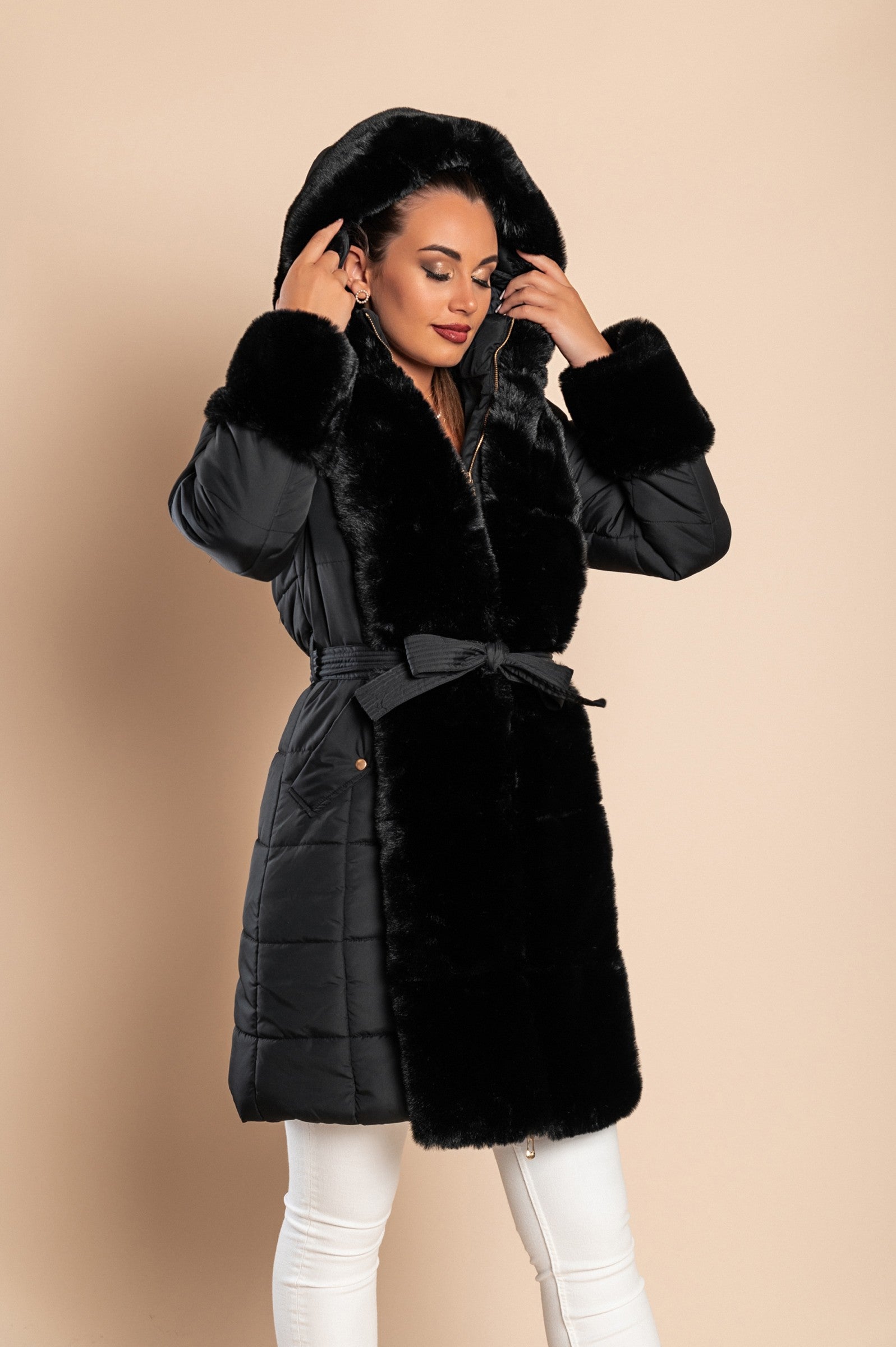 Black padded jacket with faux fur trim, featuring a metal zipper, side pockets, and a belt, designed for warmth and style.