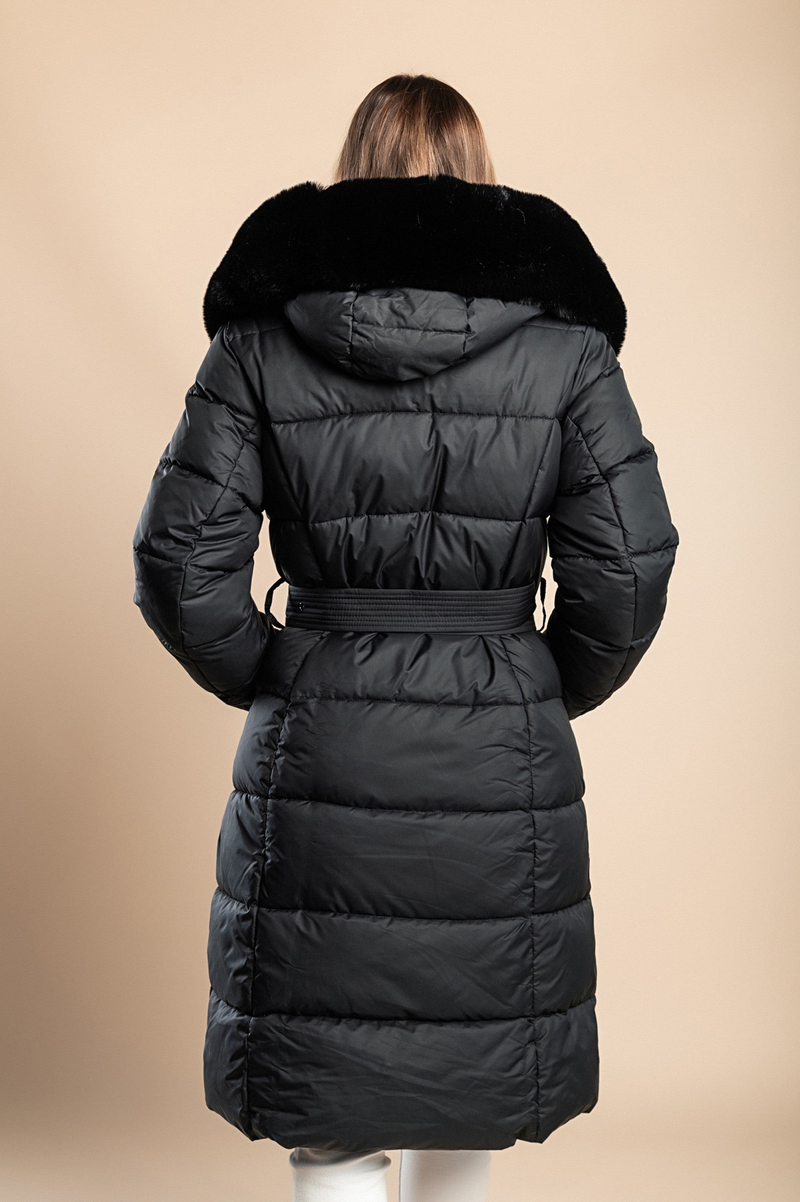 Padded black winter jacket with removable faux fur hood and decorative belt, featuring side pockets and long sleeves.