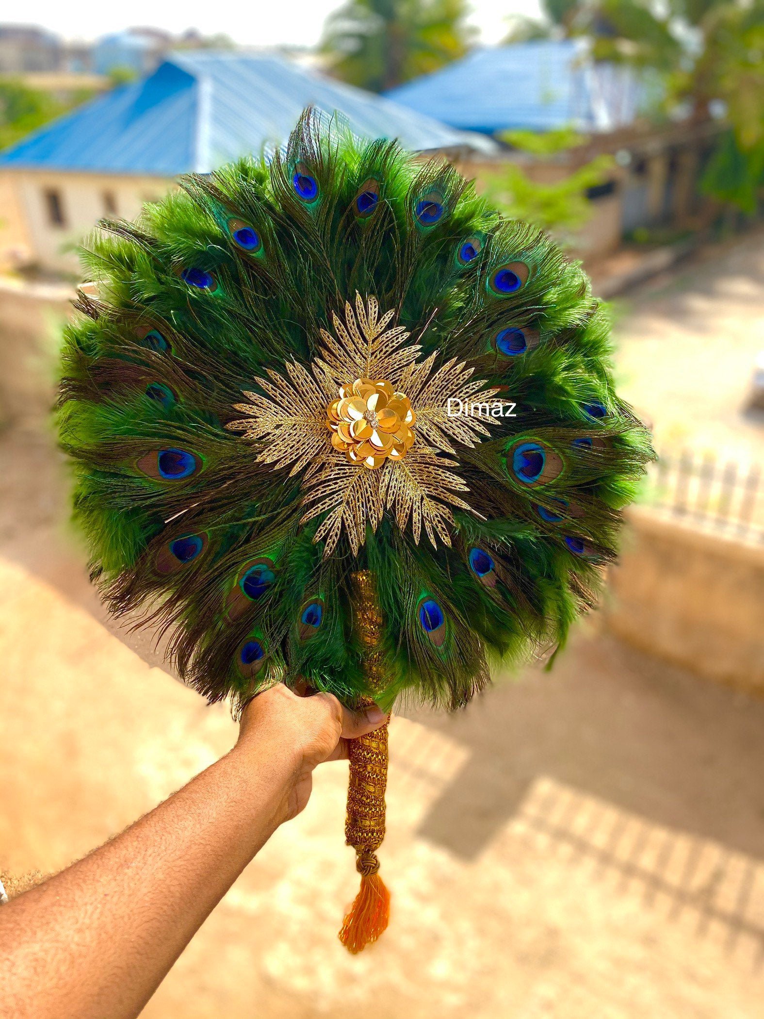 A beautiful 20-inch peacock feather hand fan with vibrant colors and an elegant design, featuring an 8-inch handle for easy use.