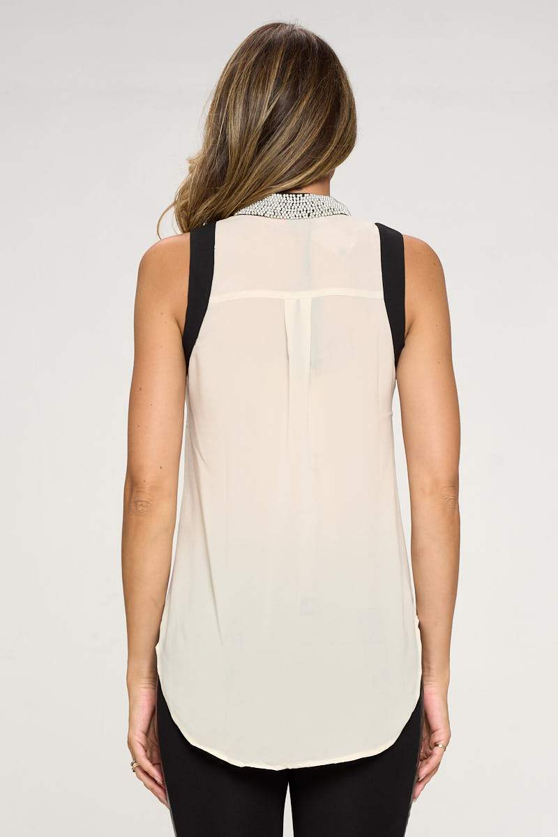 A stylish sleeveless shirt featuring a pearl collar, perfect for elegant occasions.