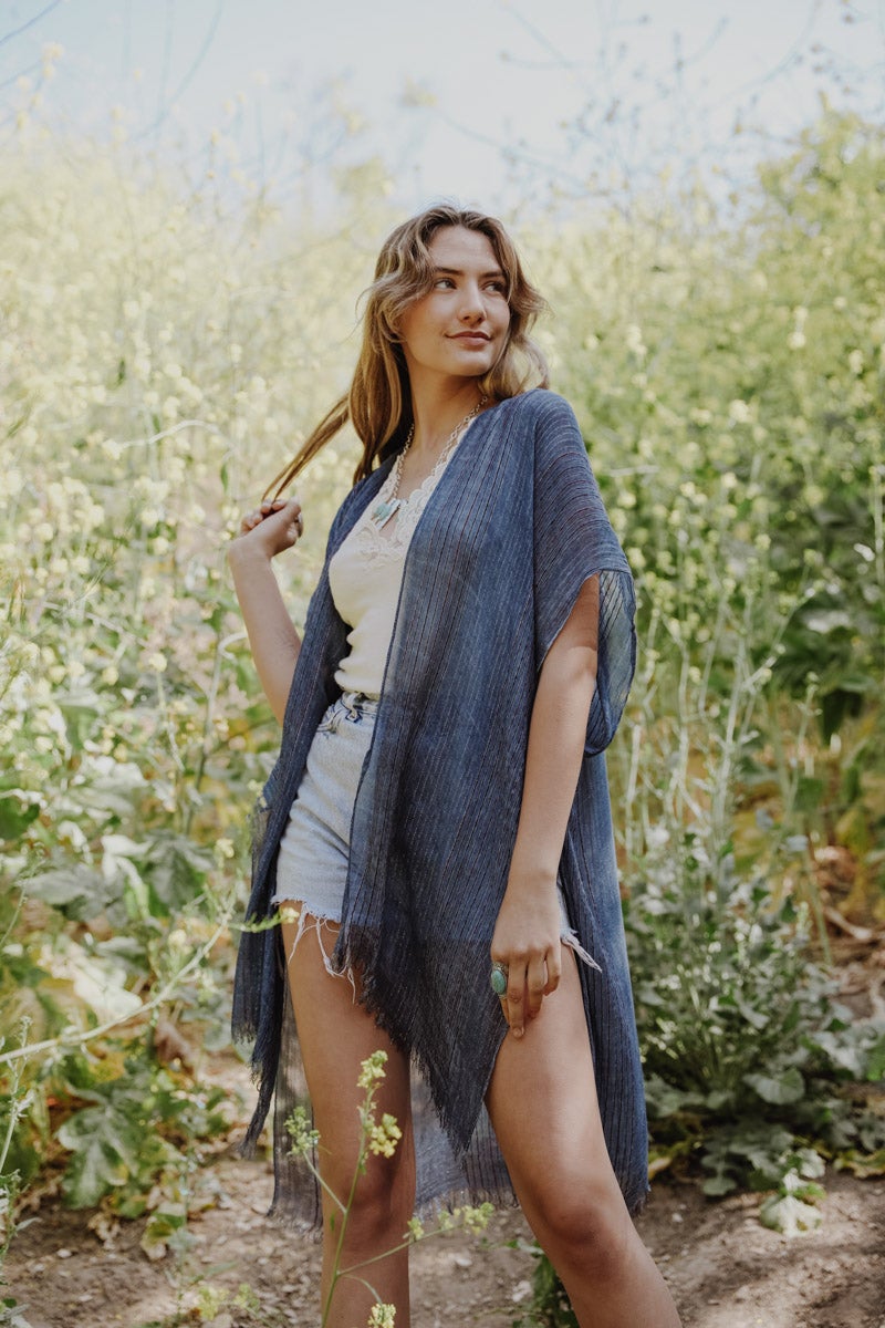 A stylish Pencil Stripe Lurex Trim Kimono featuring a chic pencil stripe pattern and elegant lurex trim, perfect for summer outings.