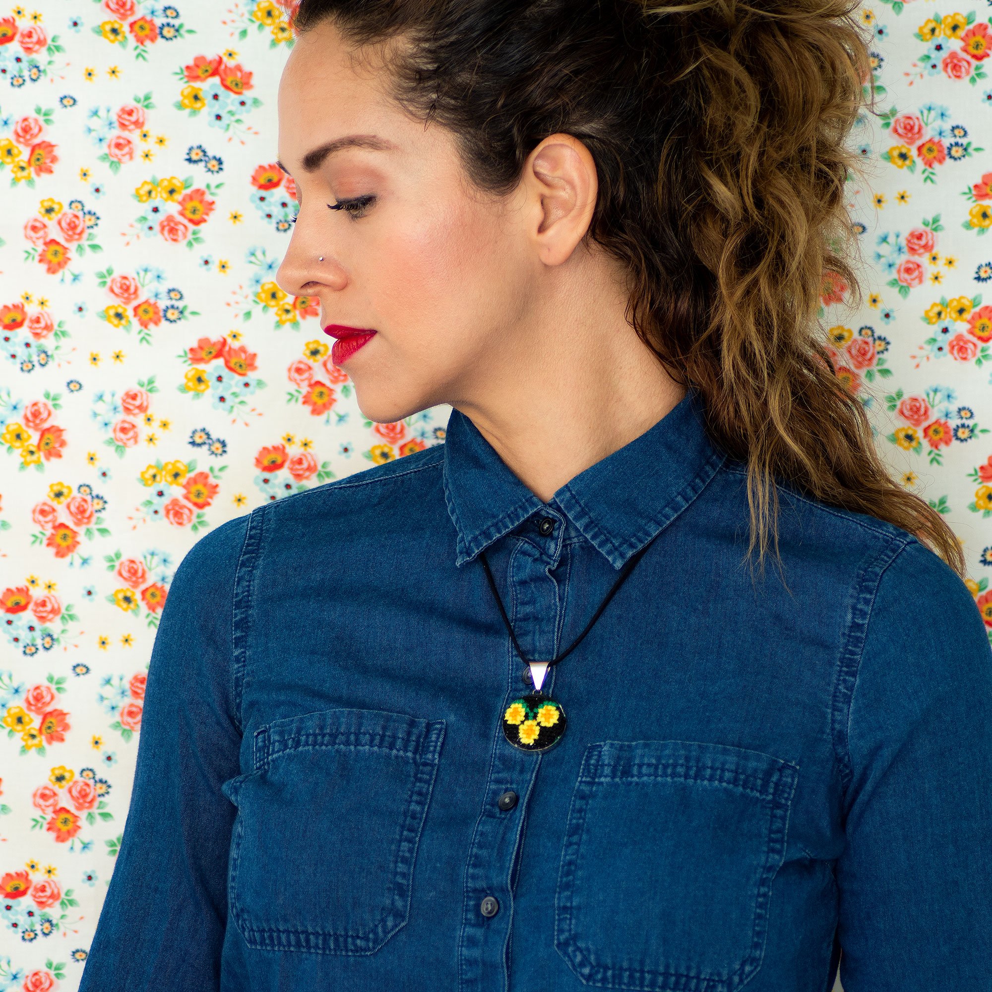 Hand embroidered circular pendant featuring vibrant yellow daisies, showcasing unique craftsmanship from Chiapas, Mexico.