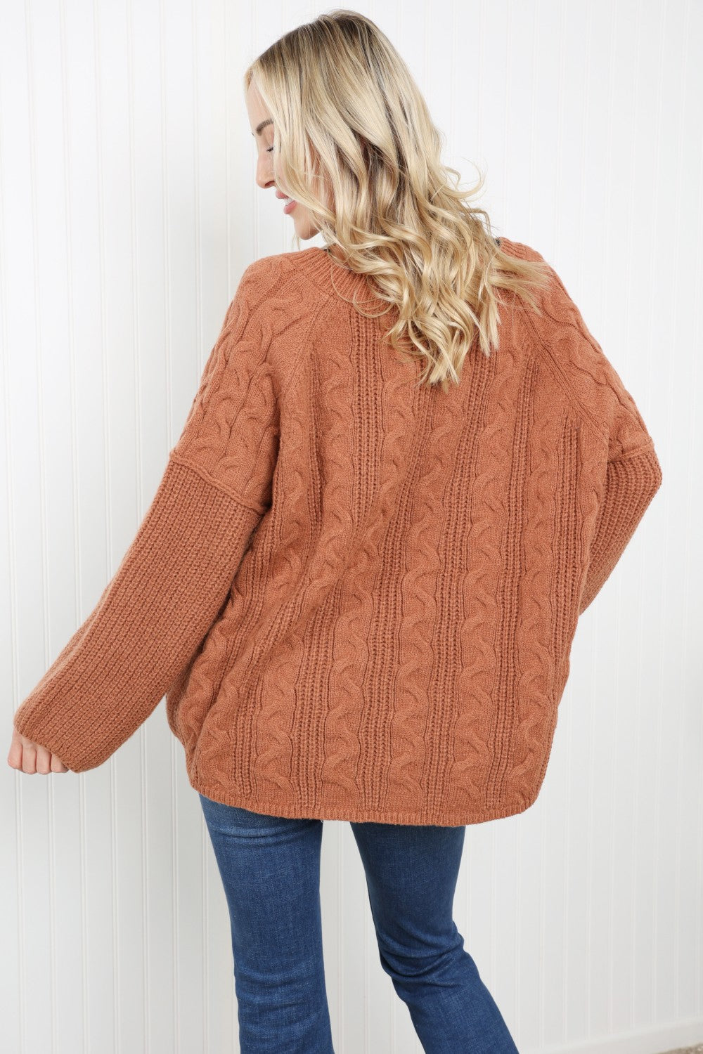 Petal Dew Cable-Knit Notched Sweater featuring a ribbed design, notched neckline, and dropped shoulders in a stylish studio setting.