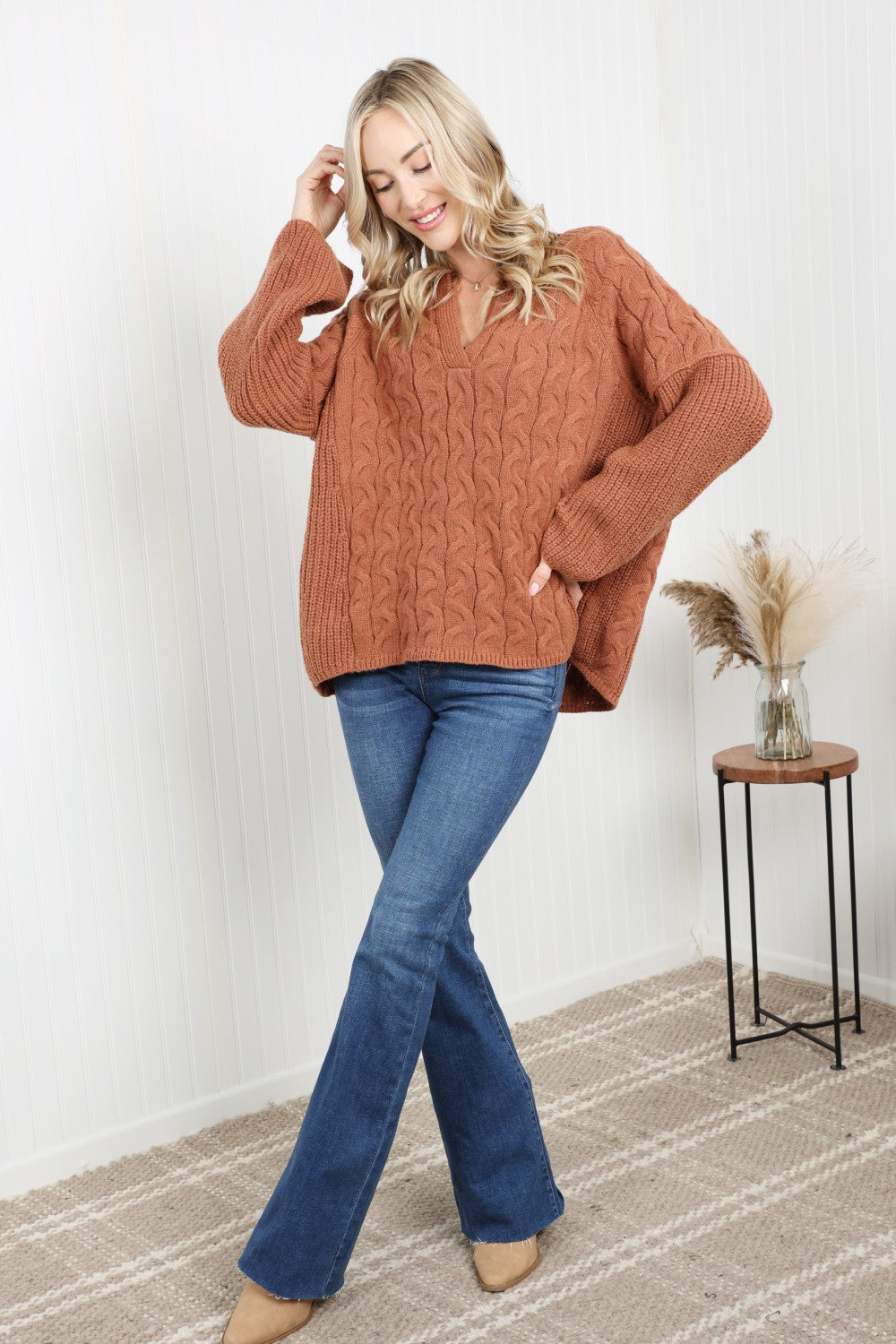 Petal Dew Cable-Knit Notched Sweater featuring a ribbed design, notched neckline, and dropped shoulders in a stylish studio setting.