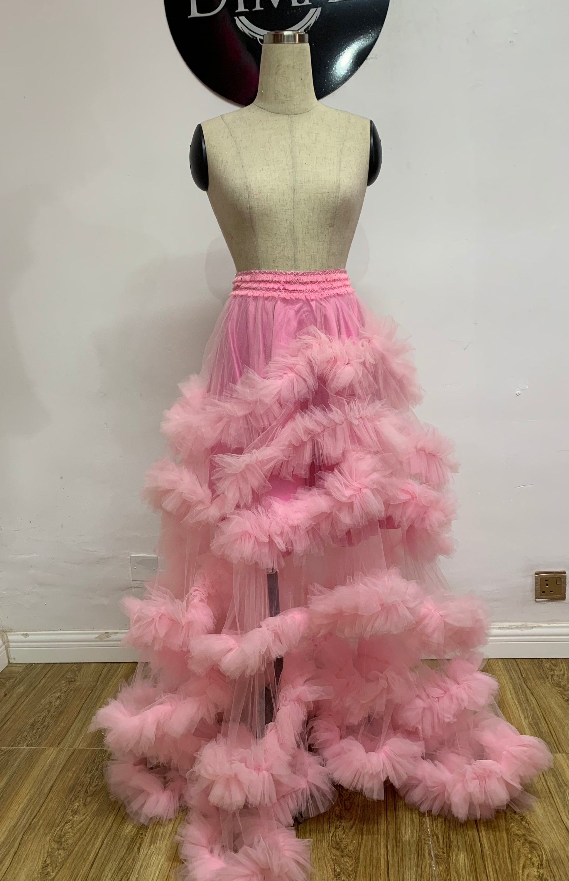 A beautiful floor-length Pink Candice Skirt made of airy tulle, featuring a tiered design and soft pink hue, perfect for romantic occasions.