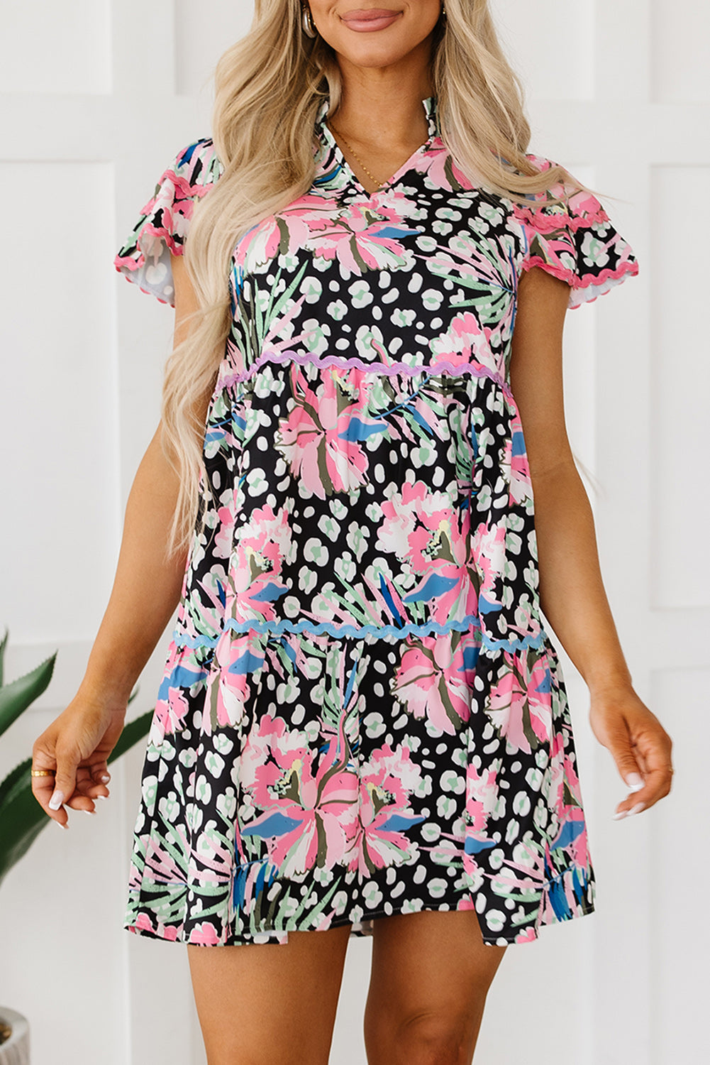 A stylish pink floral mini dress with ricrac embellishments, featuring a tiered design and short sleeves, perfect for casual outings.