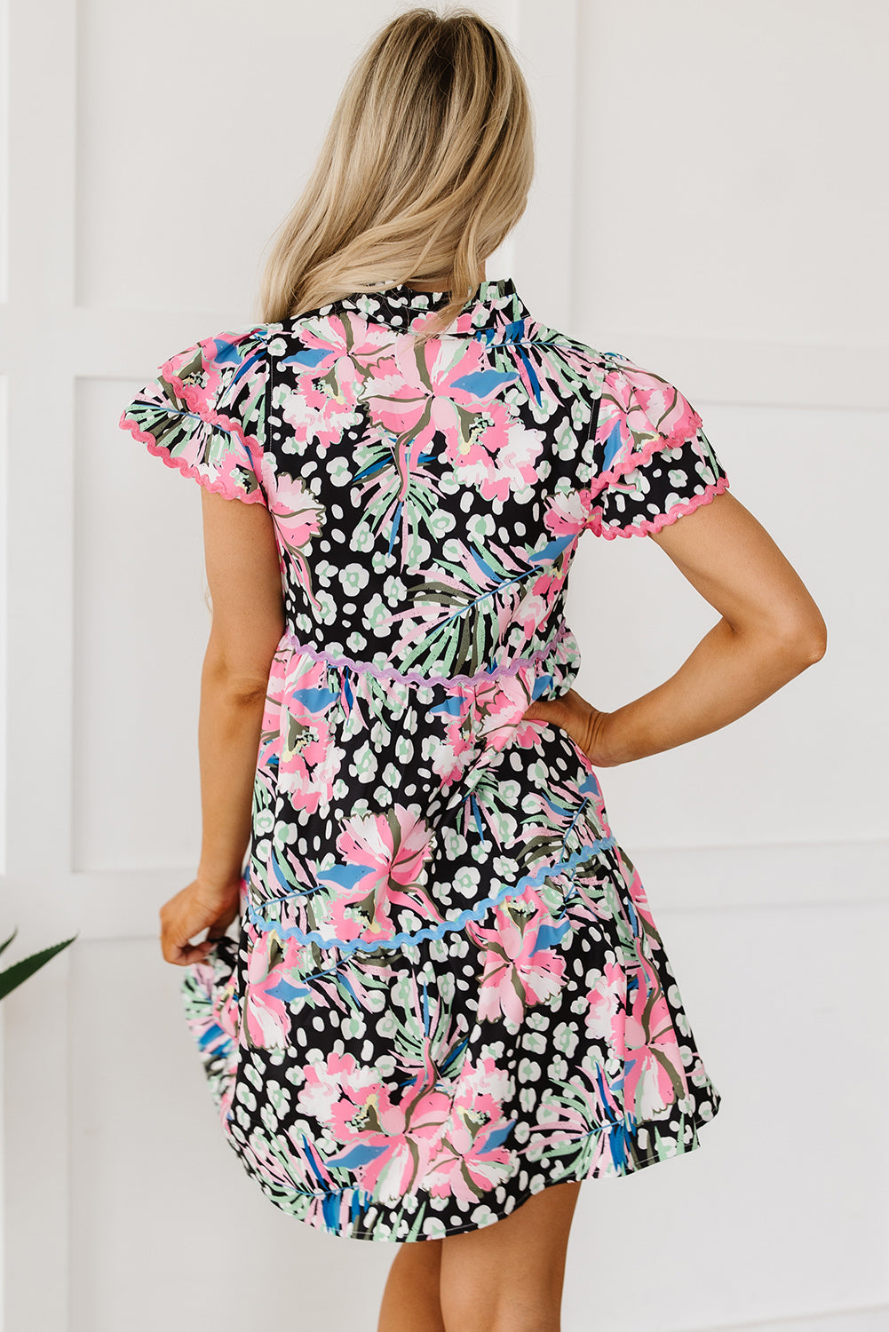 A stylish pink floral mini dress with ricrac embellishments, featuring a tiered design and short sleeves, perfect for casual outings.