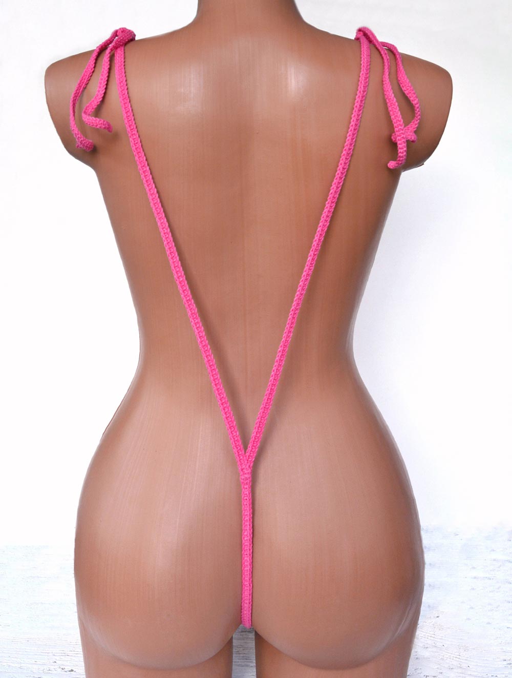 A vibrant pink micro slingshot bikini made from 100% cotton, showcasing its unique design and comfortable fit.