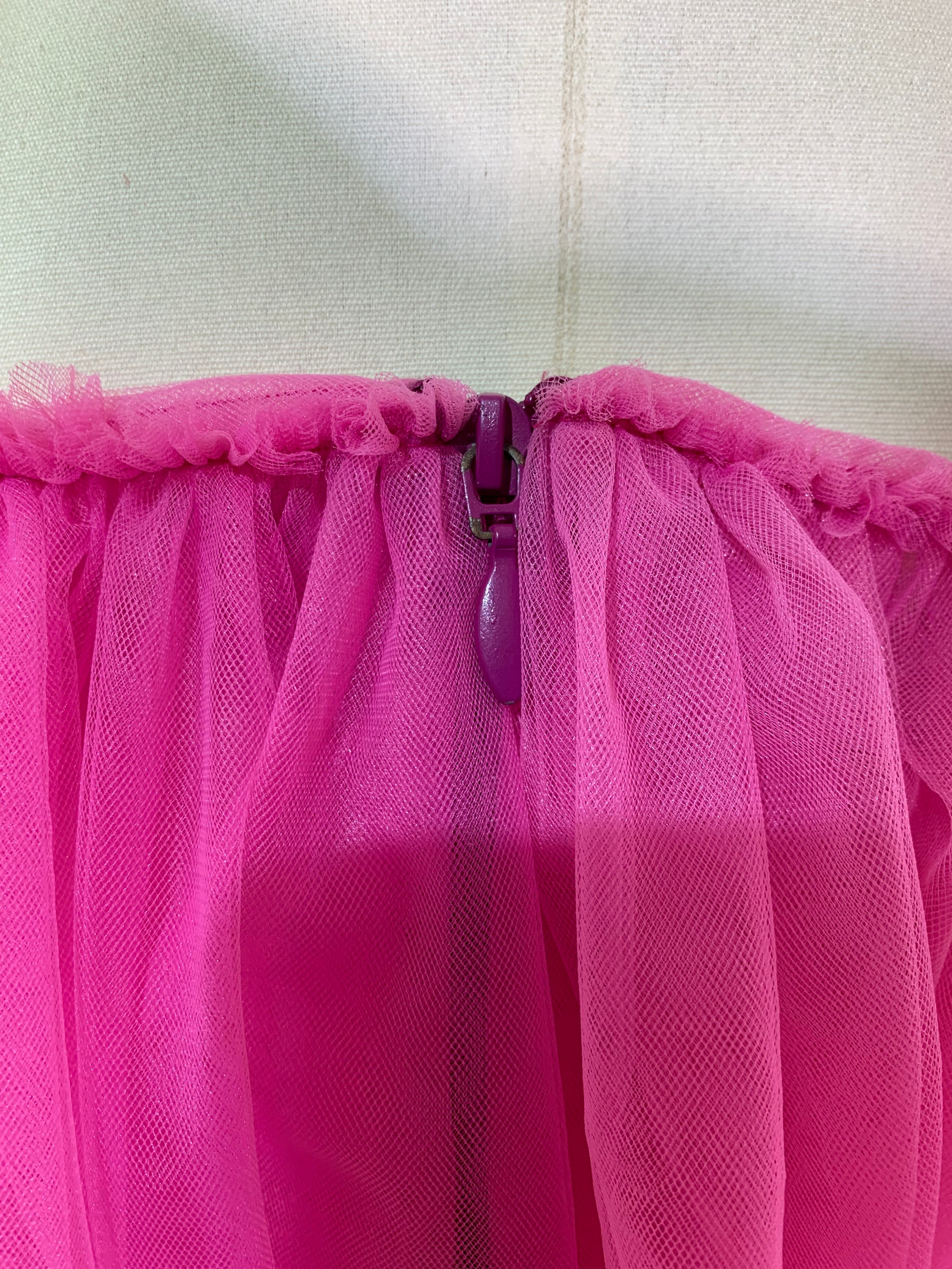 A stylish pink off-shoulder top made of delicate tulle fabric, showcasing a feminine design perfect for various occasions.