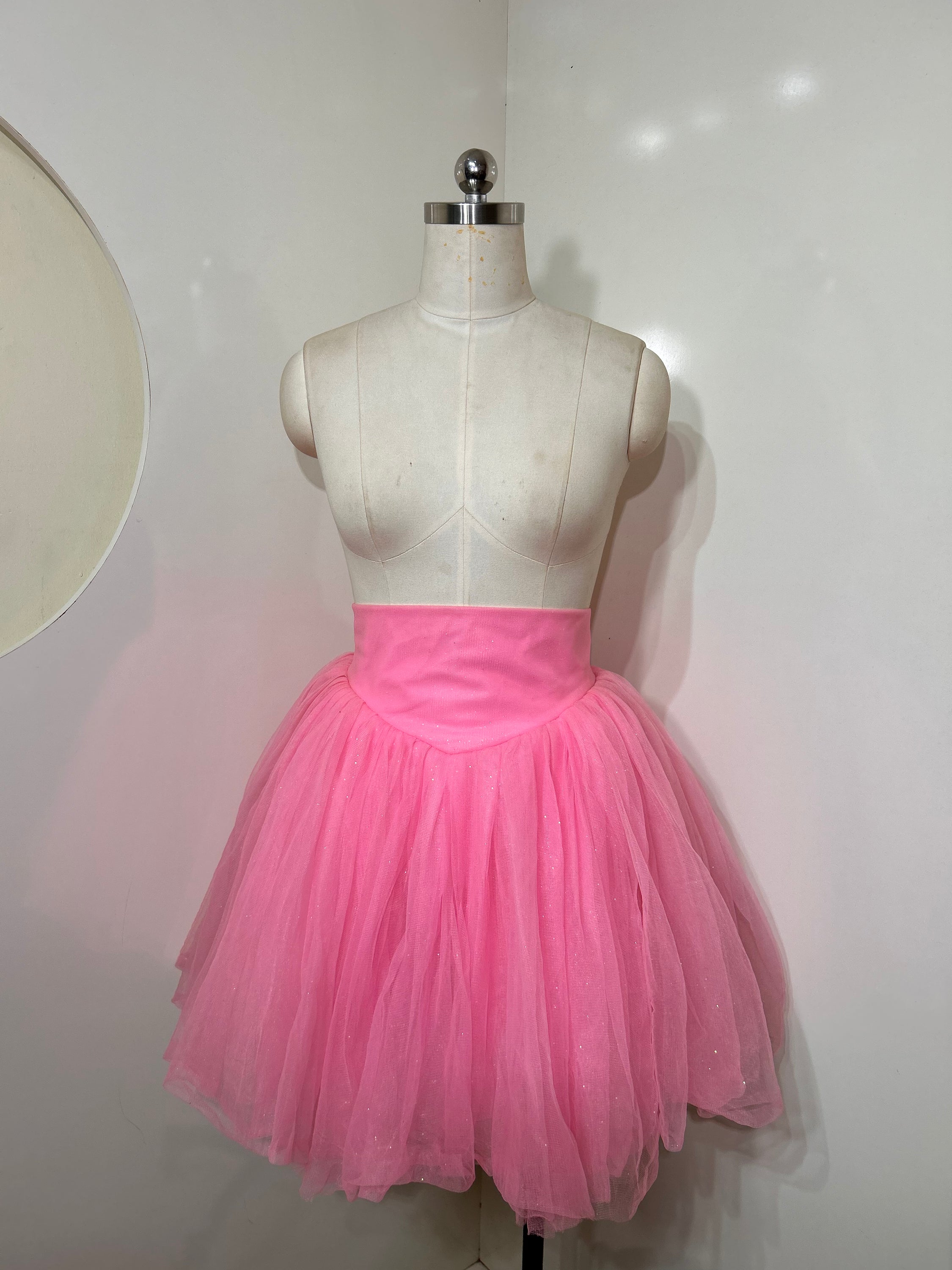 A beautiful high-waist pink shimmer tulle skirt with iridescent shimmer, perfect for special occasions.