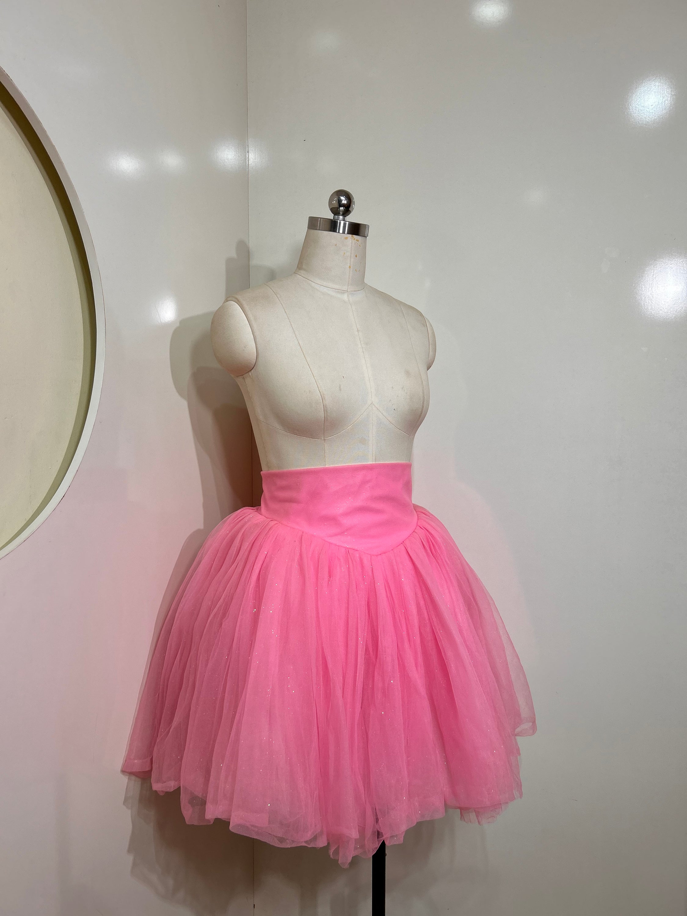 A beautiful high-waist pink shimmer tulle skirt with iridescent shimmer, perfect for special occasions.