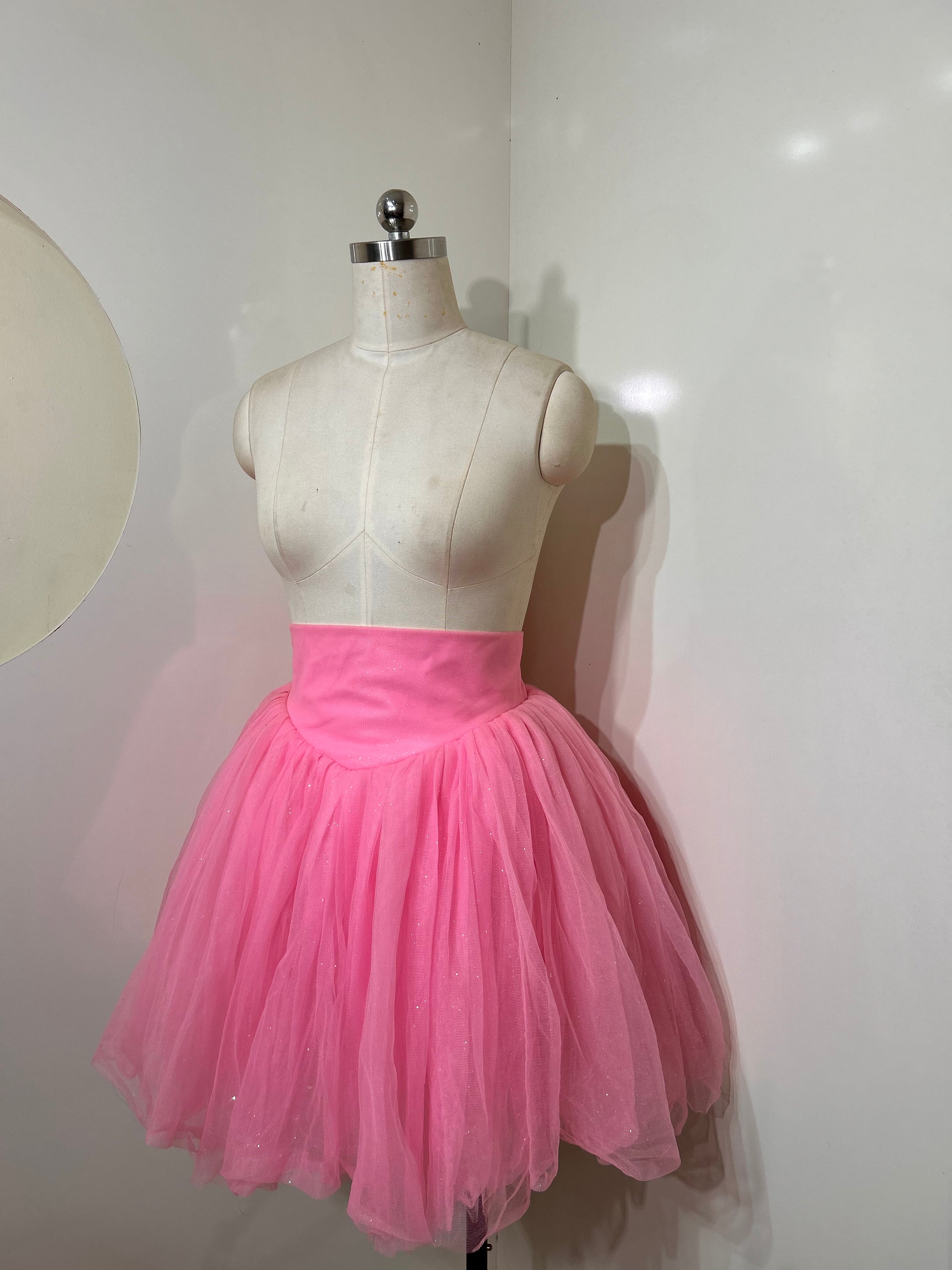 A beautiful high-waist pink shimmer tulle skirt with iridescent shimmer, perfect for special occasions.