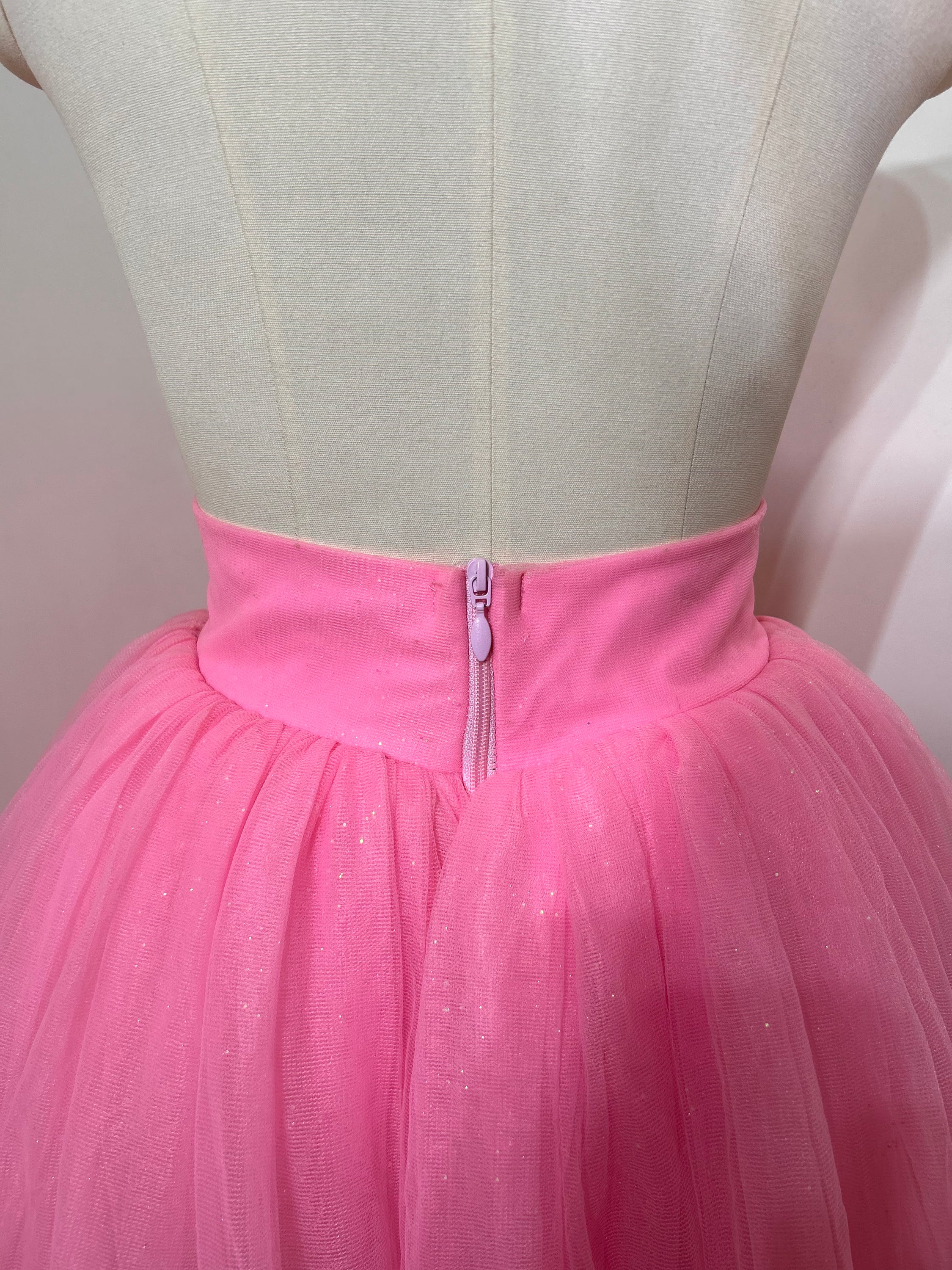 A beautiful high-waist pink shimmer tulle skirt with iridescent shimmer, perfect for special occasions.