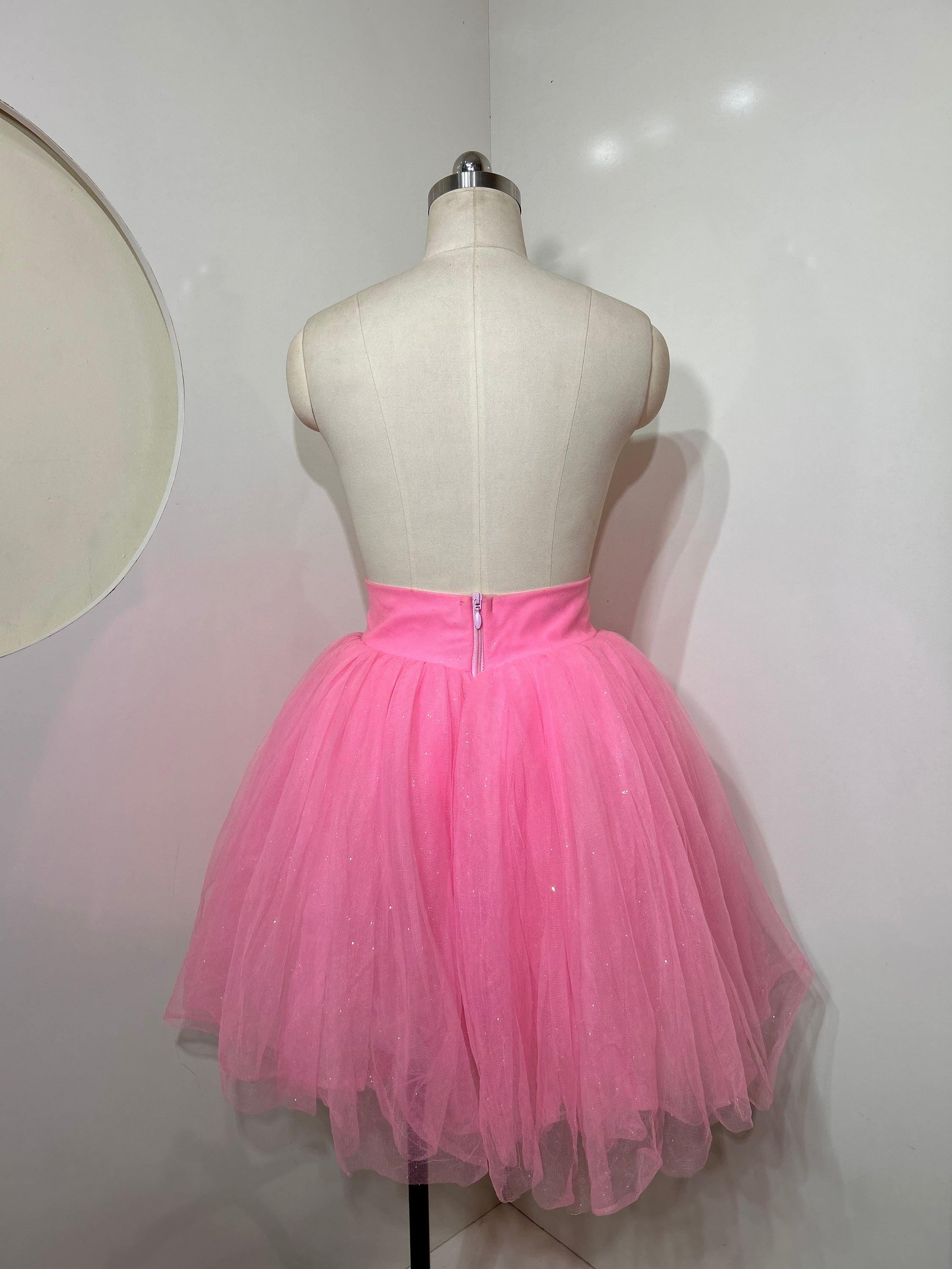 A beautiful high-waist pink shimmer tulle skirt with iridescent shimmer, perfect for special occasions.