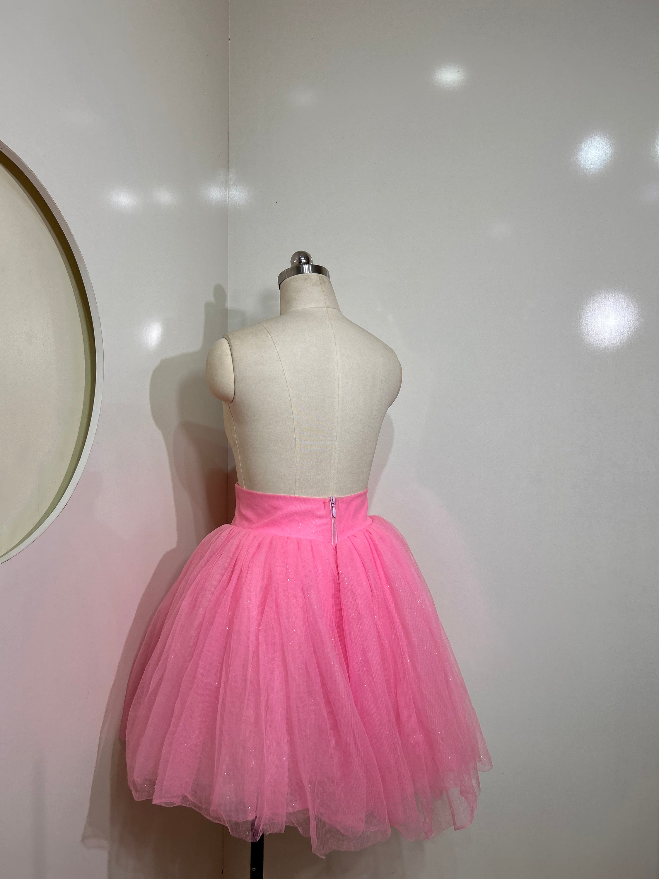 A beautiful high-waist pink shimmer tulle skirt with iridescent shimmer, perfect for special occasions.