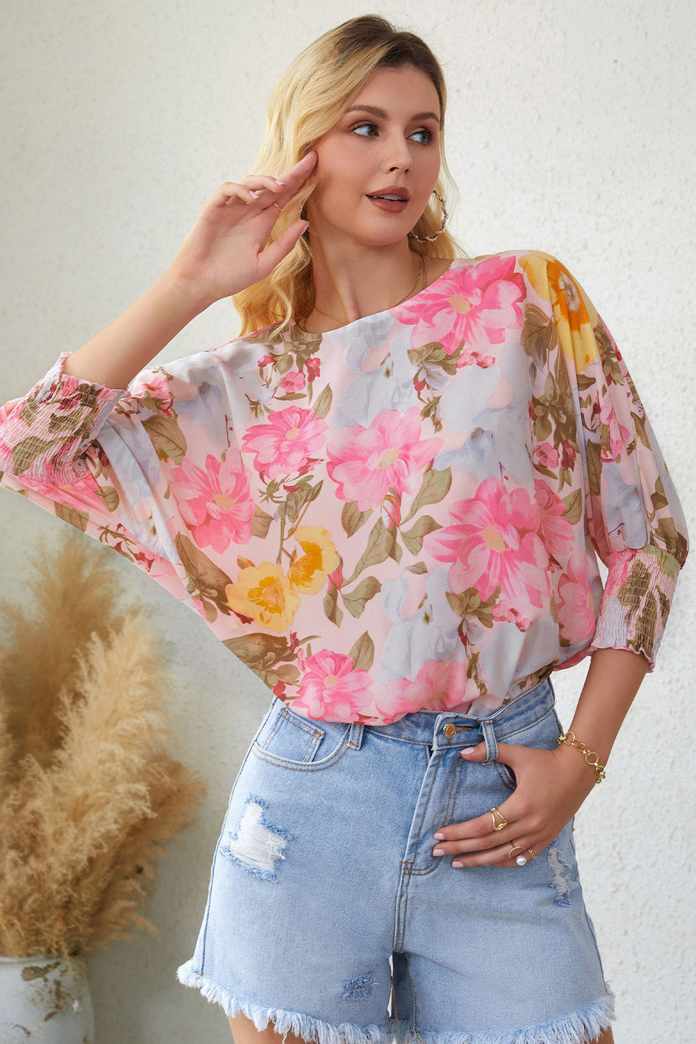 A stylish pink floral blouse with shirred cuffs and 3/4 sleeves, showcasing a loose fit design perfect for various occasions.