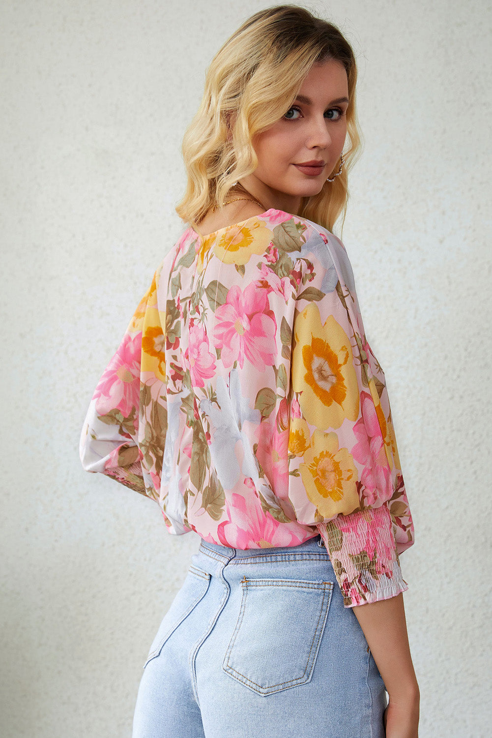 A stylish pink floral blouse with shirred cuffs and 3/4 sleeves, showcasing a loose fit design perfect for various occasions.