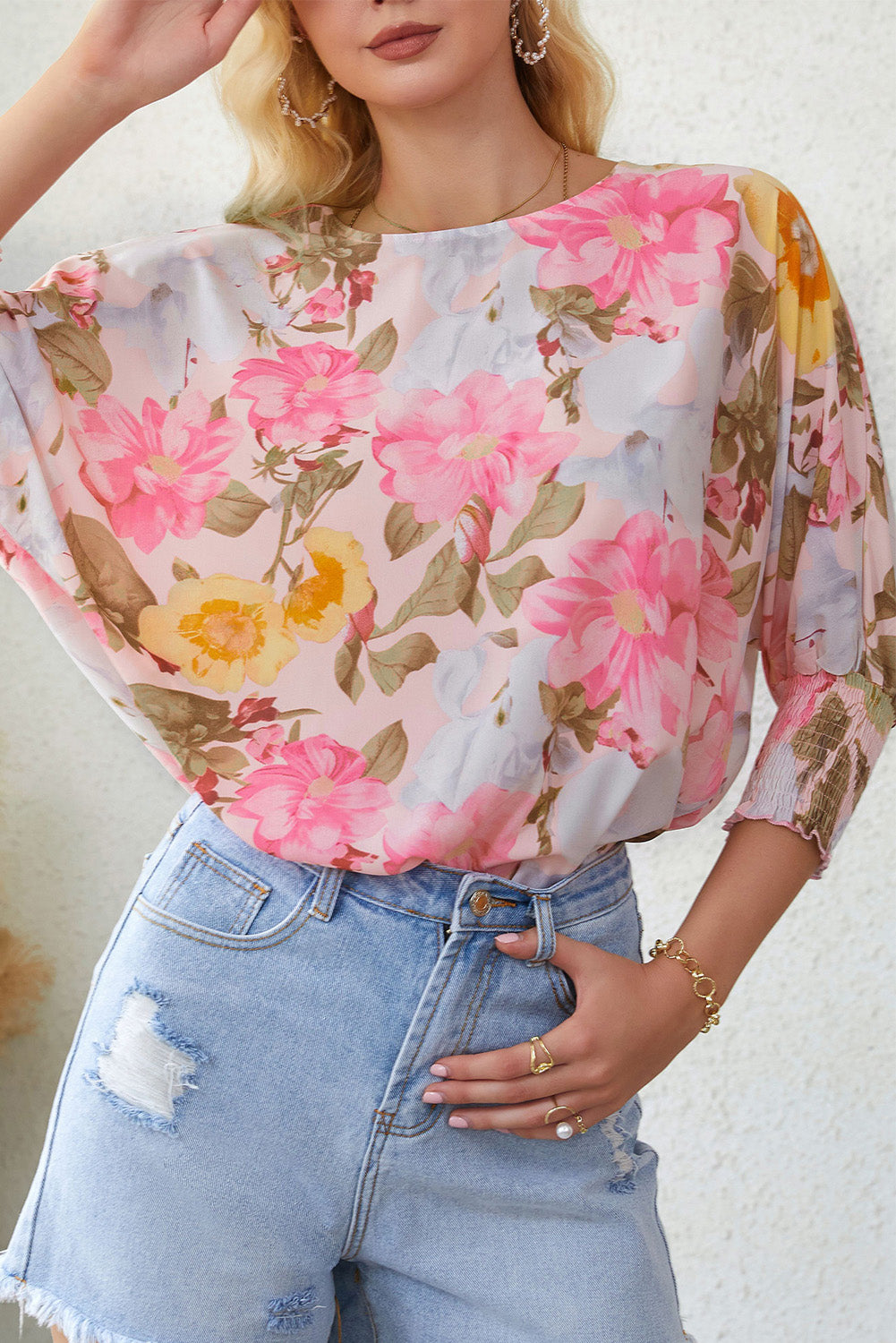 A stylish pink floral blouse with shirred cuffs and 3/4 sleeves, showcasing a loose fit design perfect for various occasions.