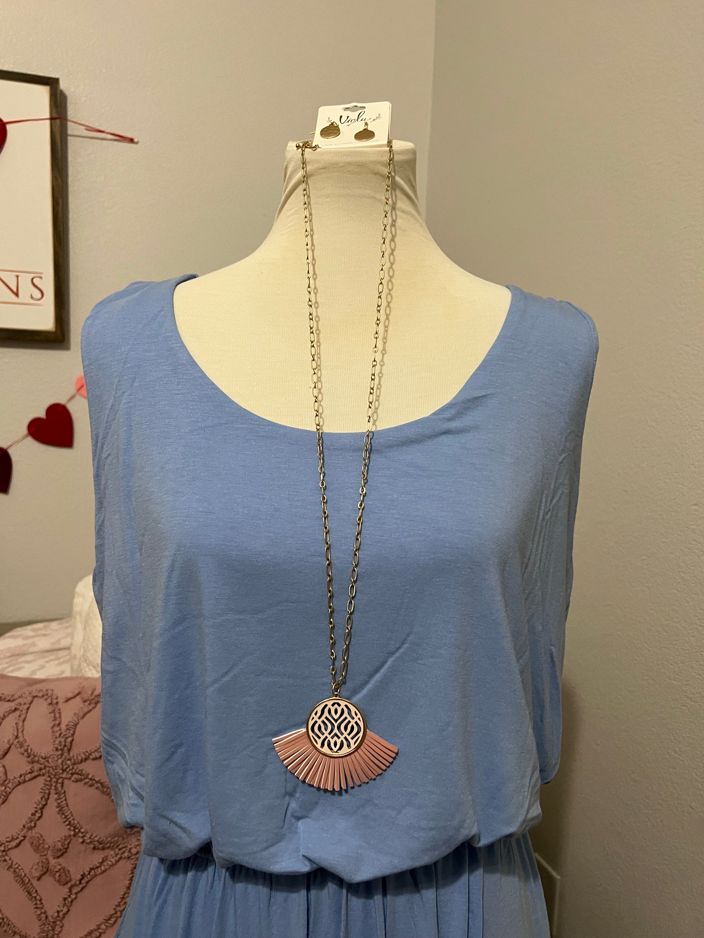 A stylish pink faux leather tassel necklace with matching disk earrings, perfect for spring fashion.