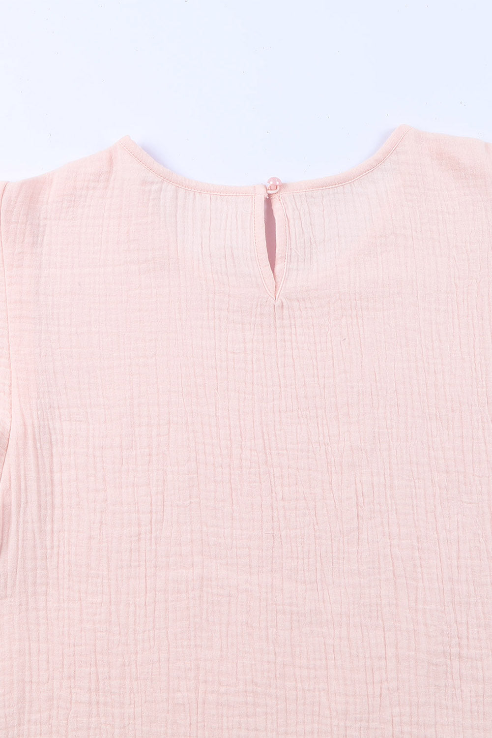 A stylish pink blouse featuring tiered ruffled sleeves and textured details, perfect for casual and formal occasions.