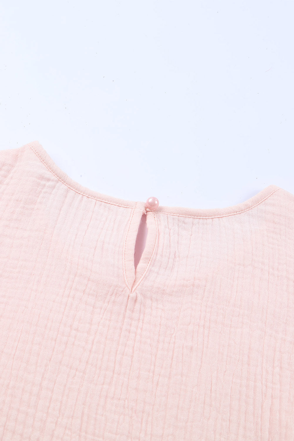 A stylish pink blouse featuring tiered ruffled sleeves and textured details, perfect for casual and formal occasions.