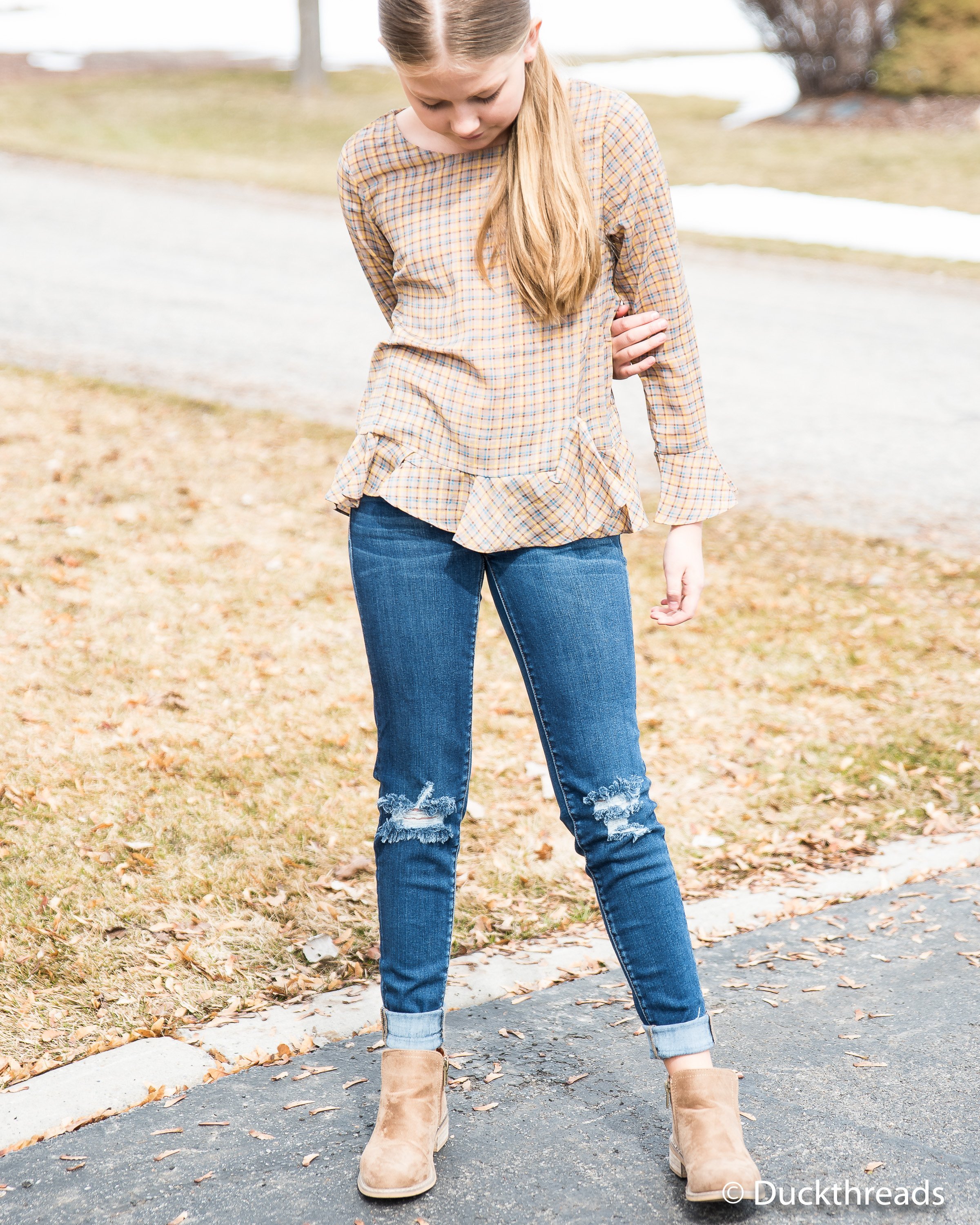 A stylish plaid bell sleeve top made from 100% polyester, featuring a trendy design and comfortable fit.