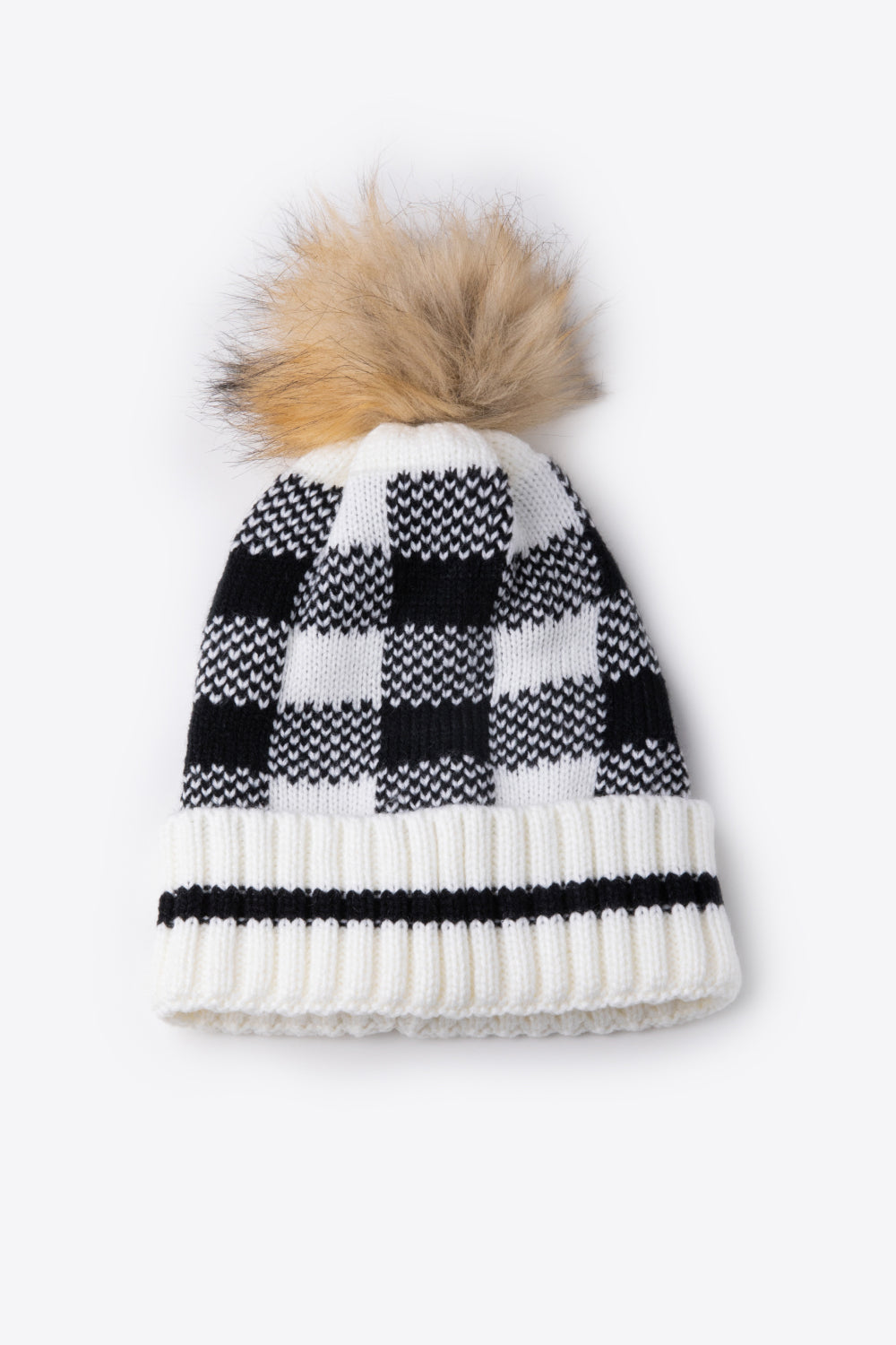 A stylish plaid pom-pom knit beanie in a flat lay style, showcasing its soft acrylic material and trendy design.