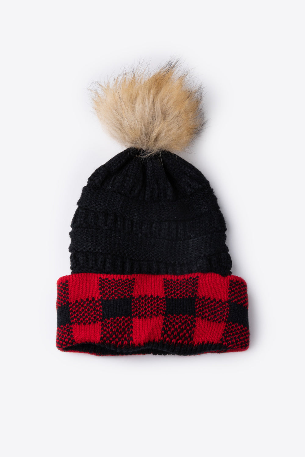 A stylish plaid pom-pom knit beanie in a flat lay style, showcasing its soft acrylic material and trendy design.