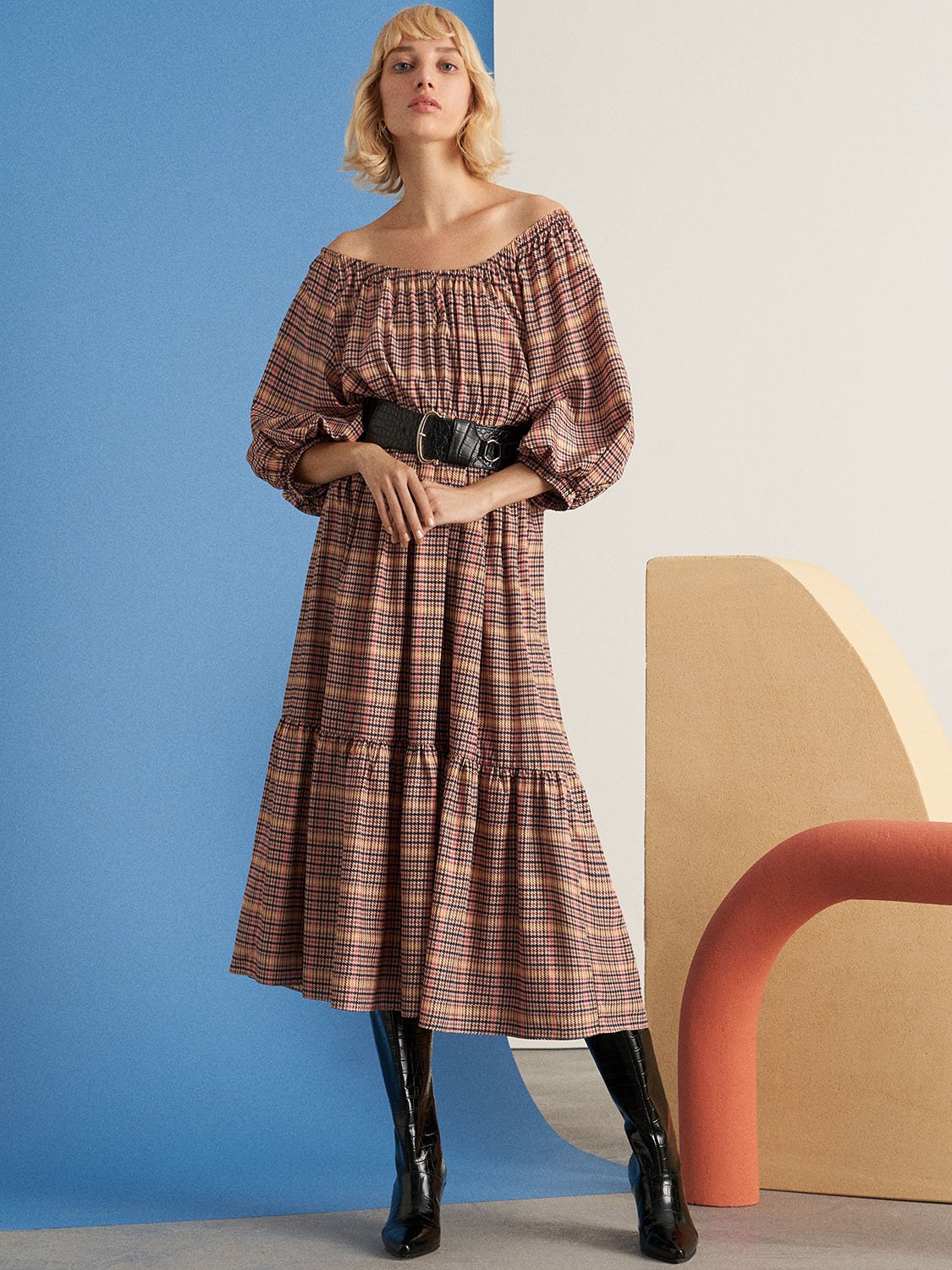 A stylish plaid smocked dress featuring a round neck, full elbow-length sleeves, and an elastic waistband, perfect for various occasions.