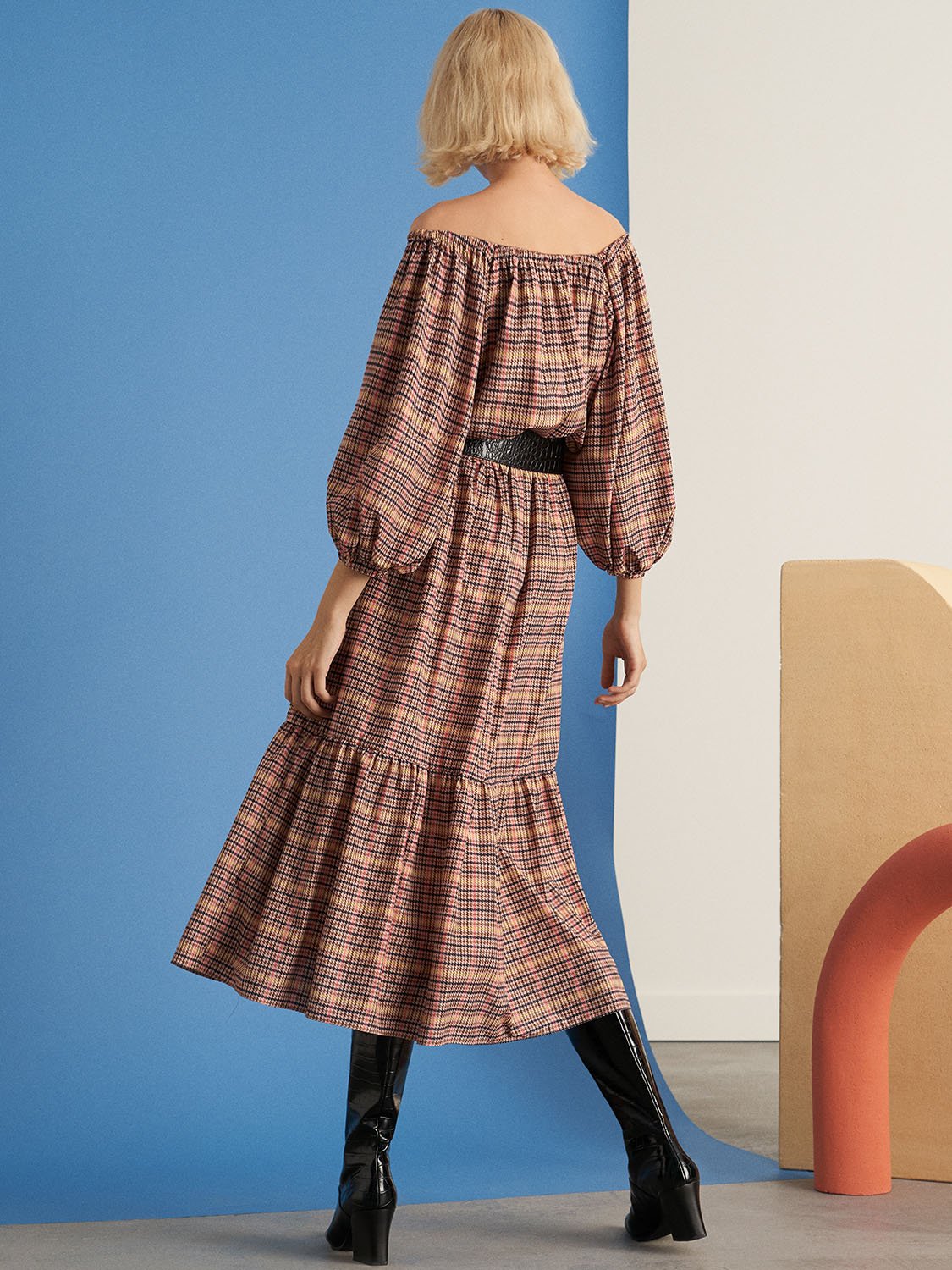 A stylish plaid smocked dress featuring a round neck, full elbow-length sleeves, and an elastic waistband, perfect for various occasions.